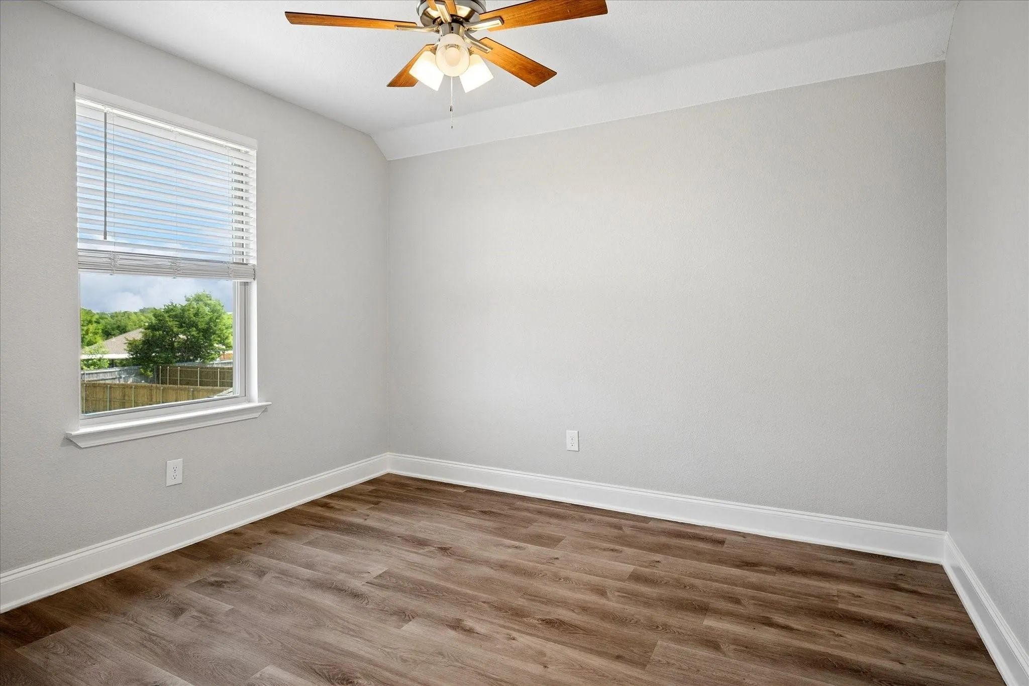Bedroom featuring wood-finish flooring, a ceiling fan, crown molding, and a window with blinds