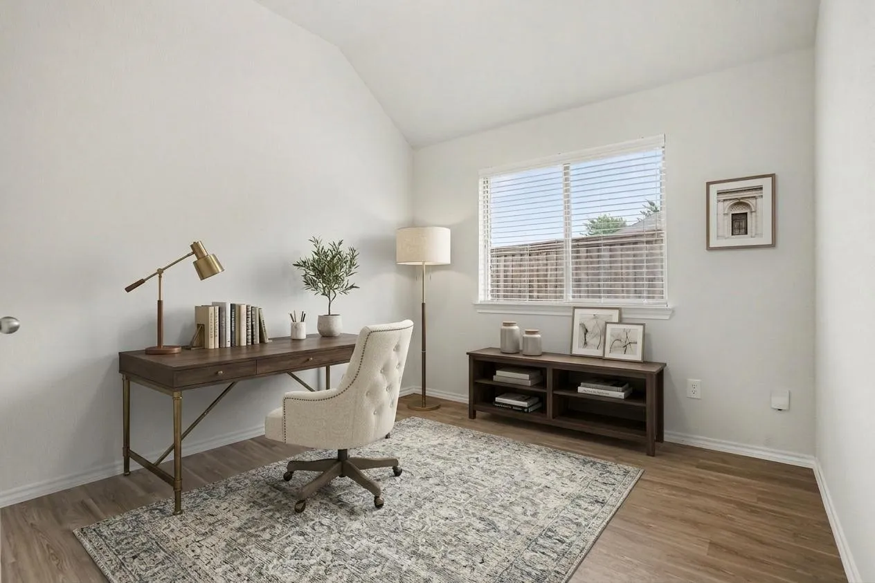 Virtually staged bright office featuring wood-finish flooring, a vaulted ceiling, and a large window with horizontal blinds