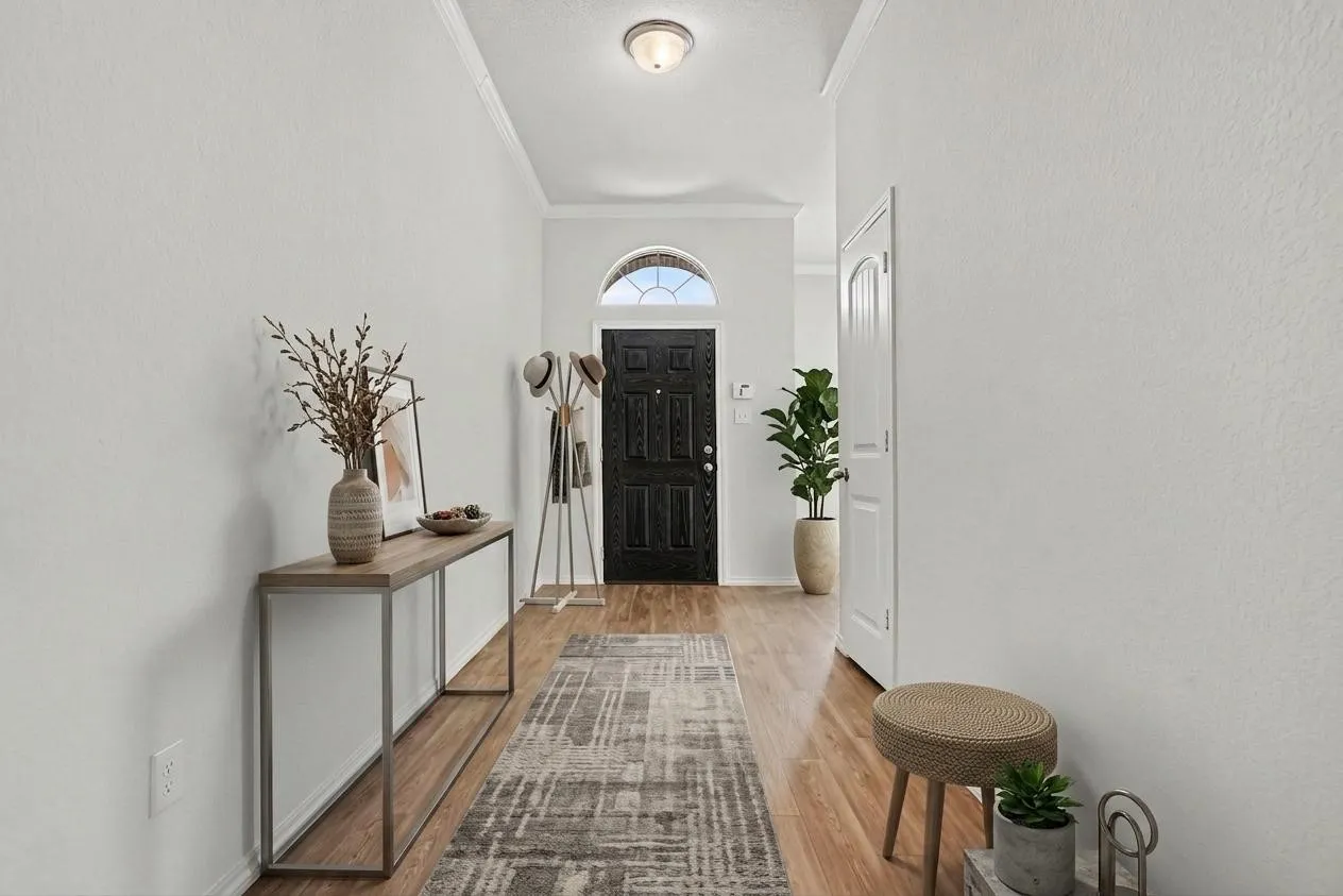 Virtually staged hallway featuring wood-finish flooring, white walls, and crown molding