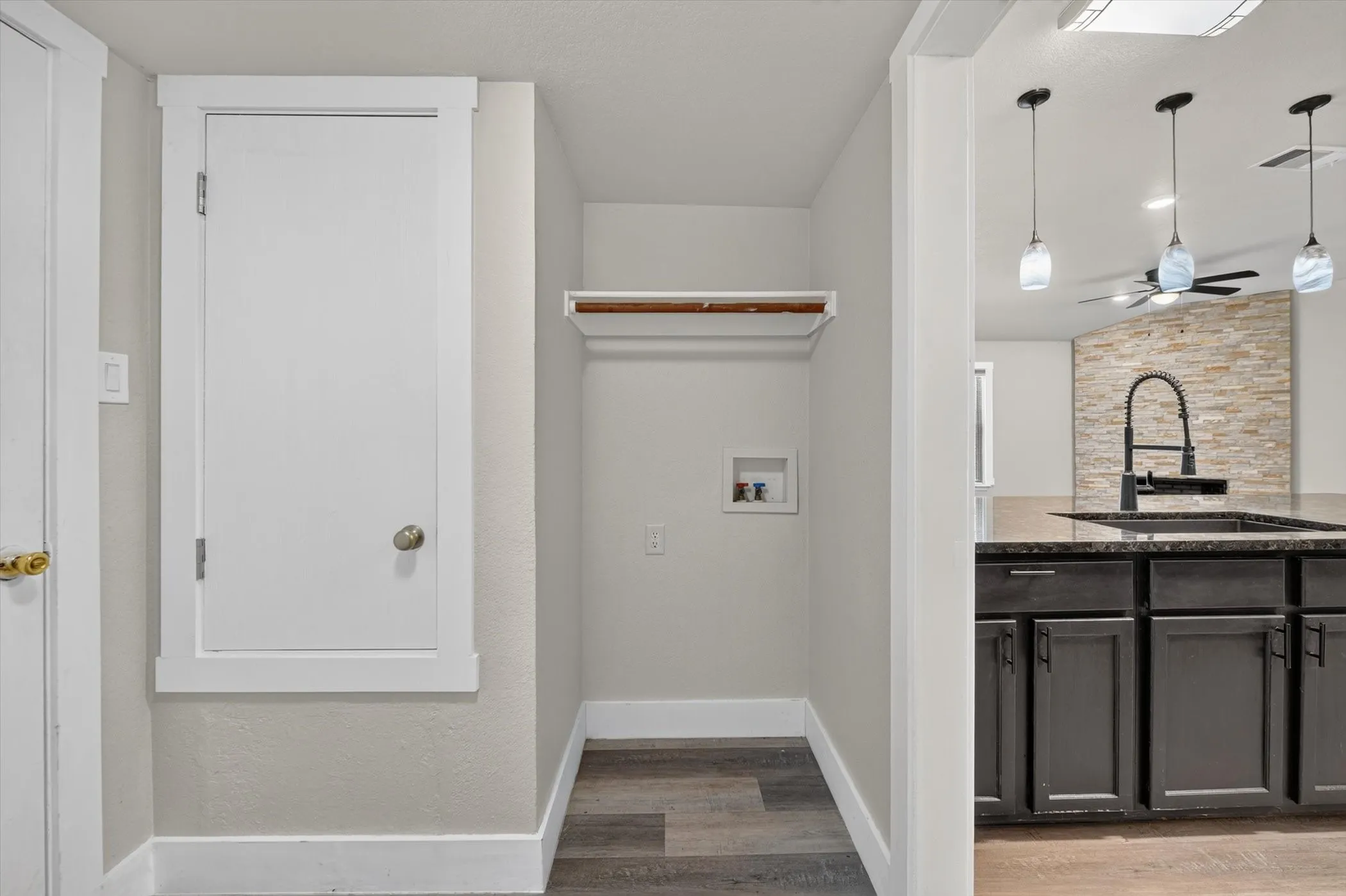 Dedicated laundry area featuring hookups and a storage shelf