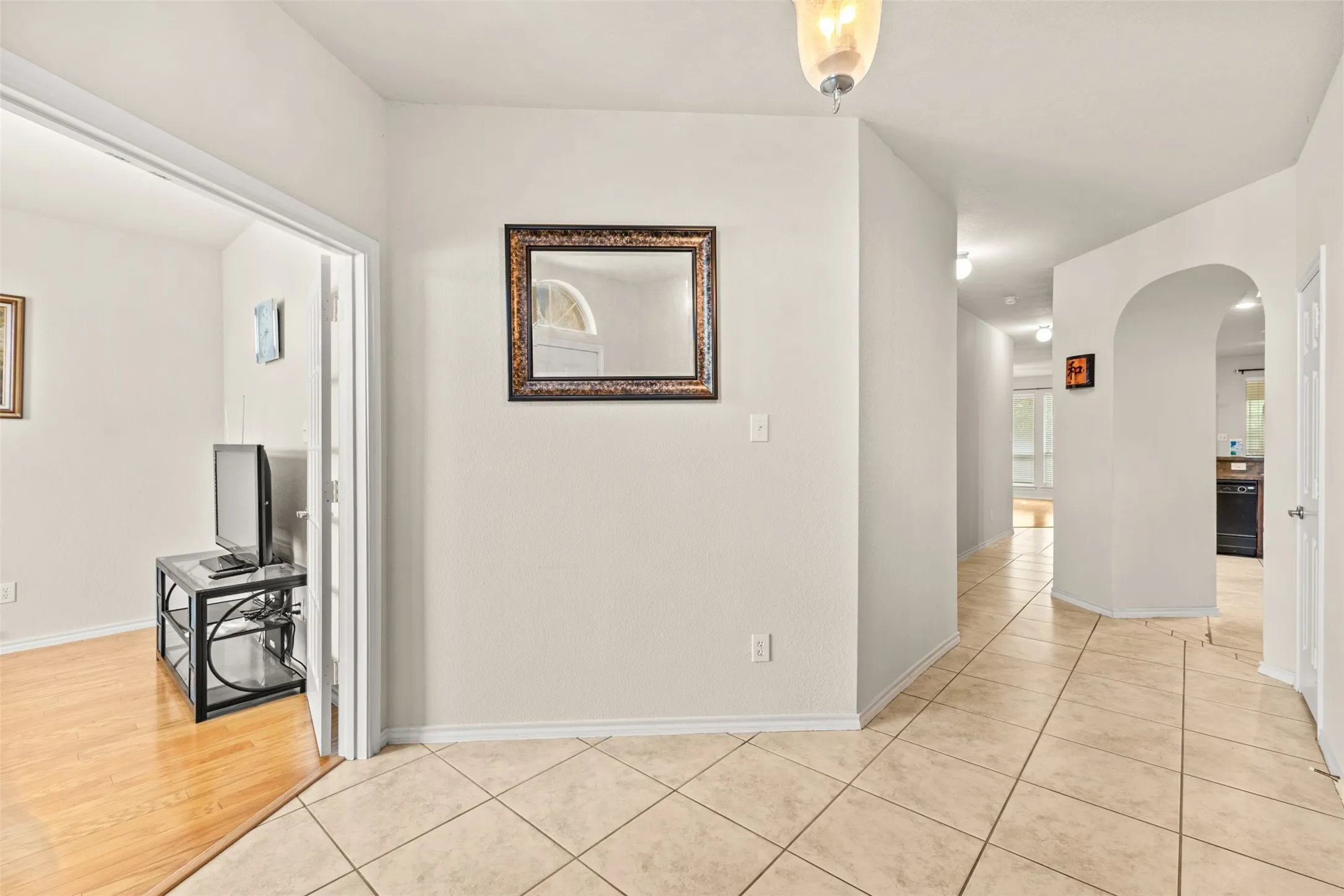 Entryway featuring neutral wall tones, square tile flooring, and an arched doorway