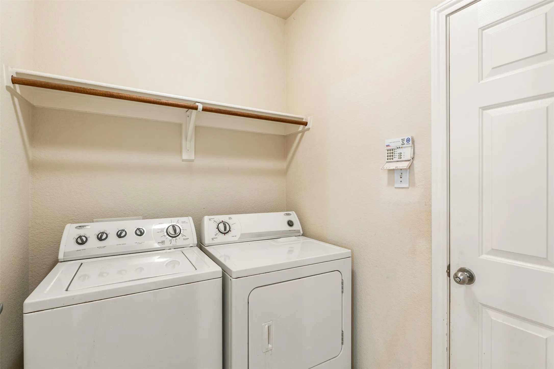 Dedicated laundry space featuring a white top-load washer and front-load dryer