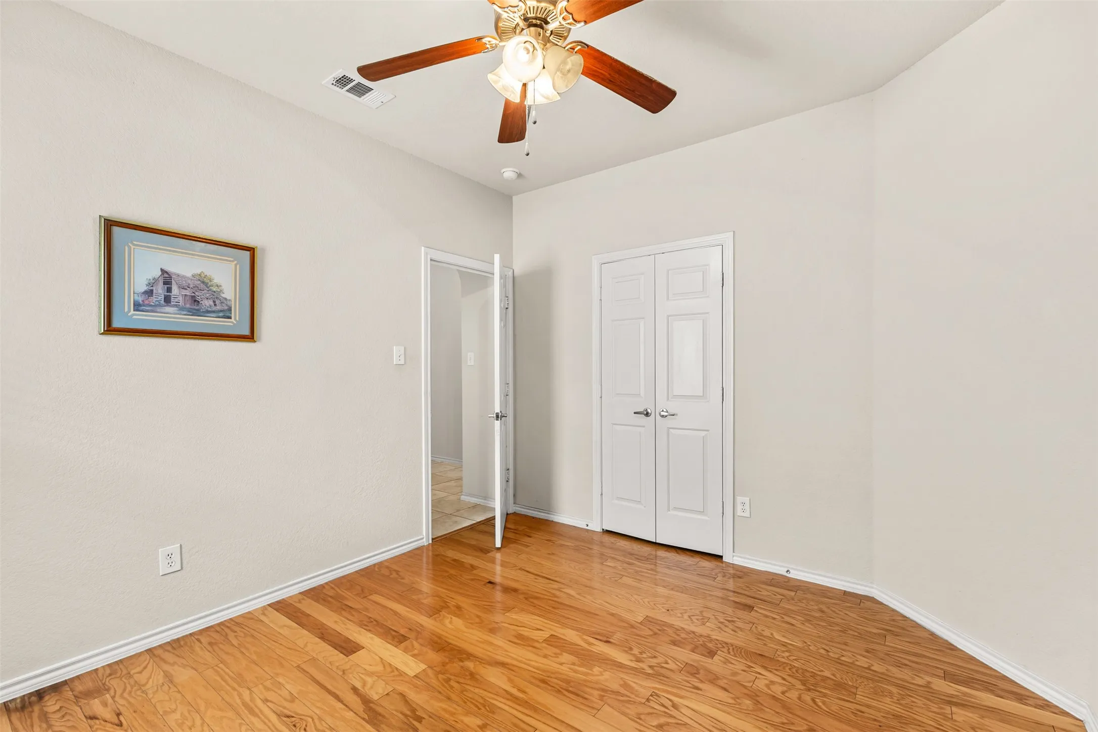 Room featuring wood-finish flooring and light-toned walls