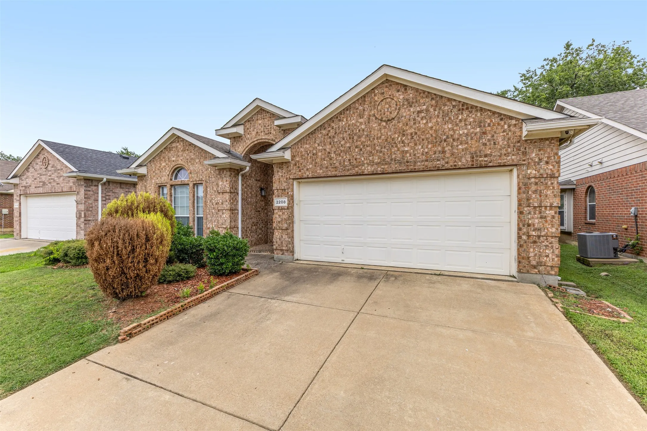 Brick exterior with a gabled roofline and attached two-car garage