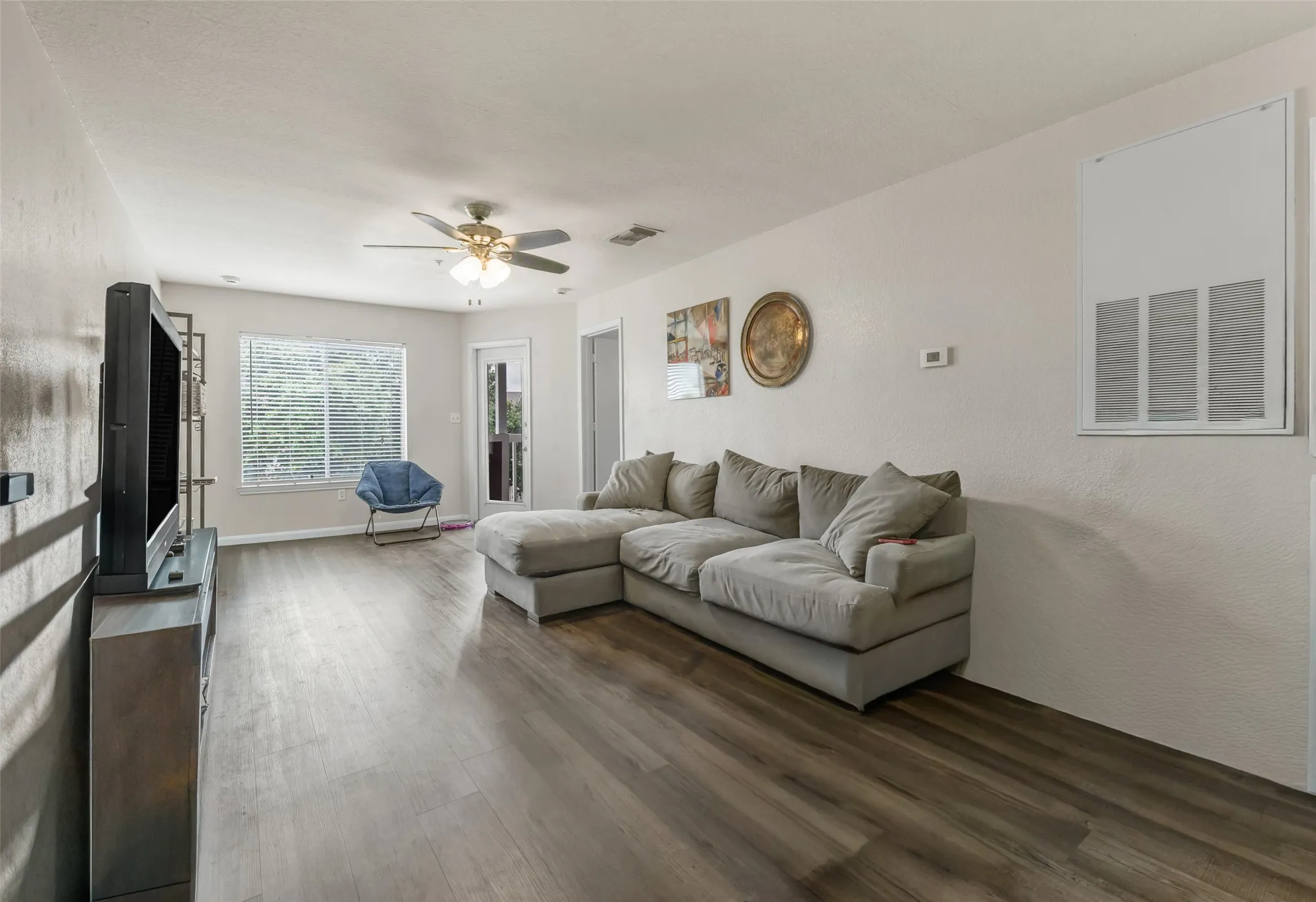 Open concept living space featuring lots of natural light , a ceiling fan, and a large window with blinds