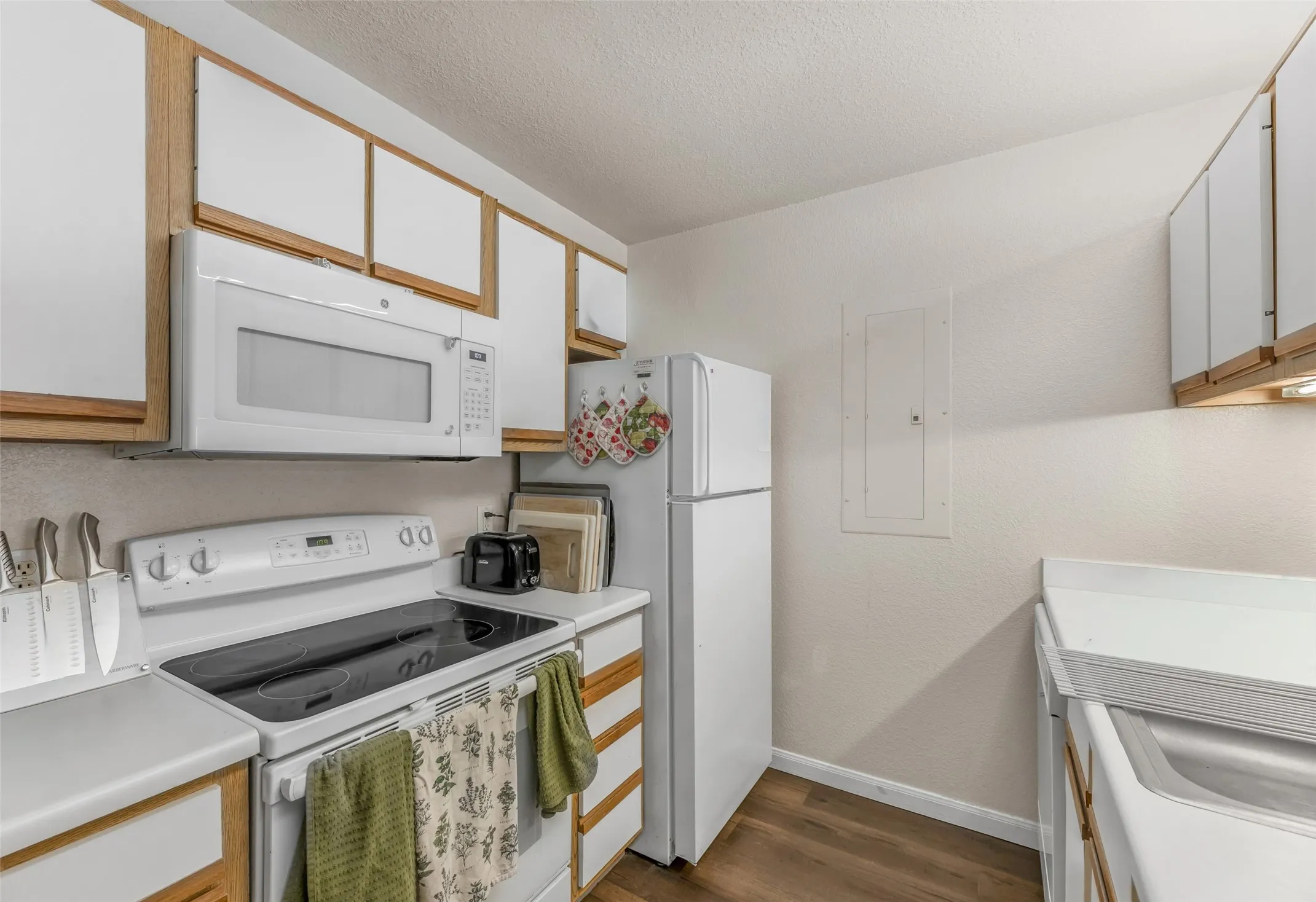 Kitchen featuring white appliances including a built-in microwave, electric range, dishwasher and refrigerator