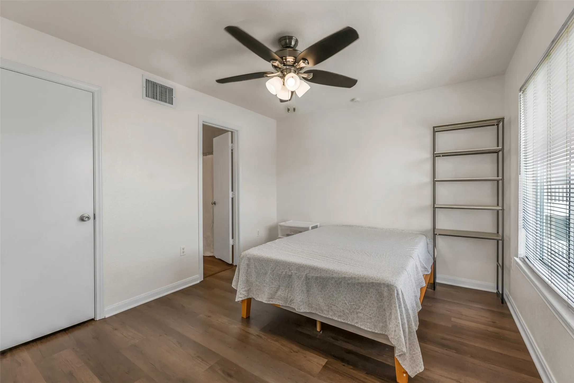 Bedroom featuring luxury vinyl plank  flooring, a ceiling fan with integrated lighting, and white window blinds