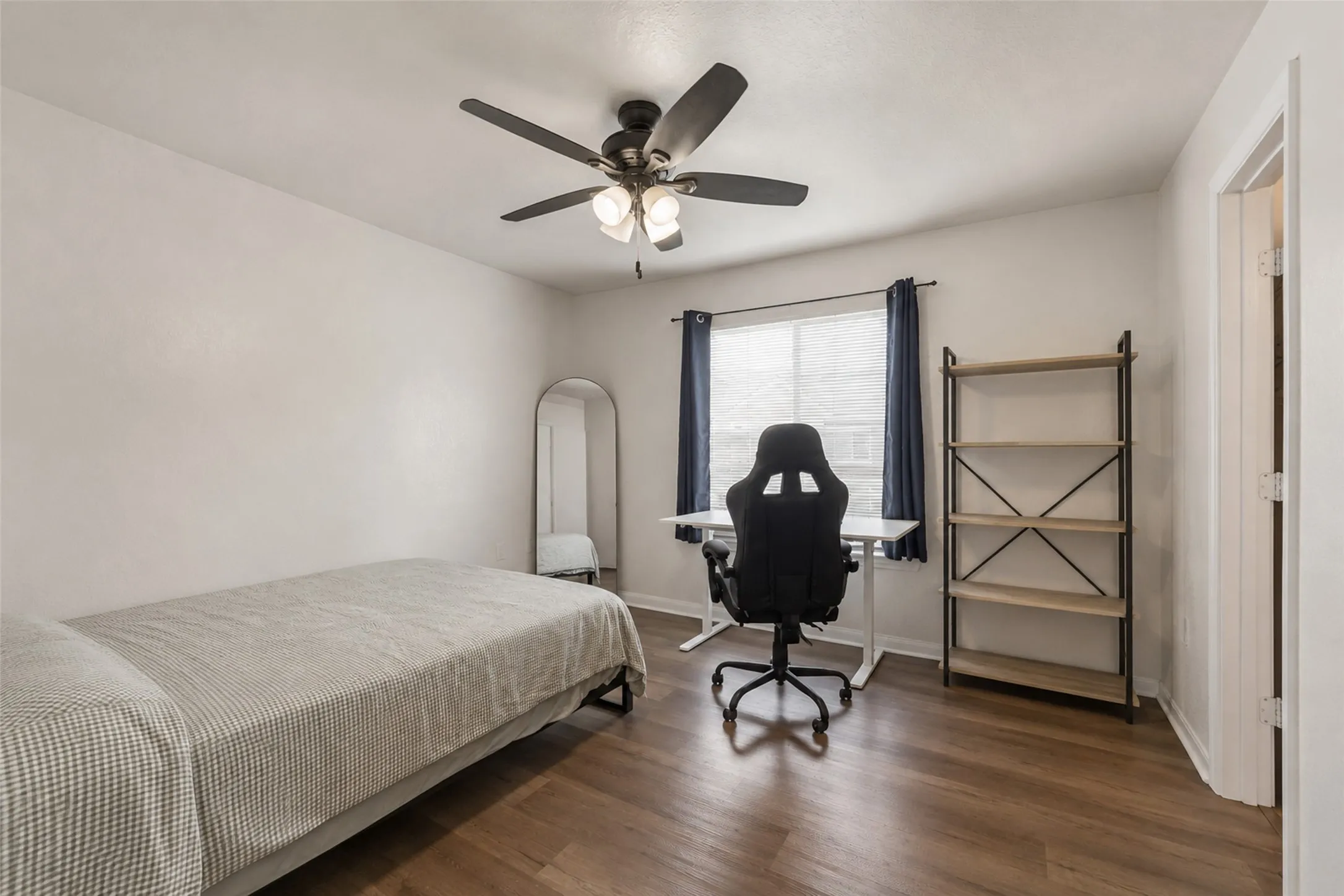 Bright interior featuring luxury vinyl plank wood-finish flooring, a ceiling fan with integrated lighting, window with blinds  and white wall finishes