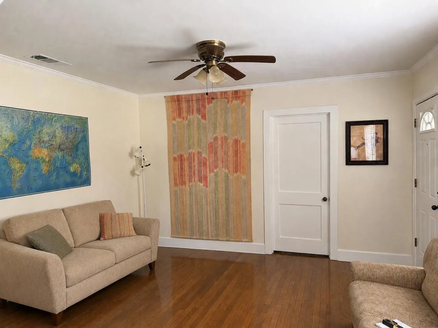 Hardwood-finish flooring throughout, complemented by crown molding and a ceiling fan with integrated lighting