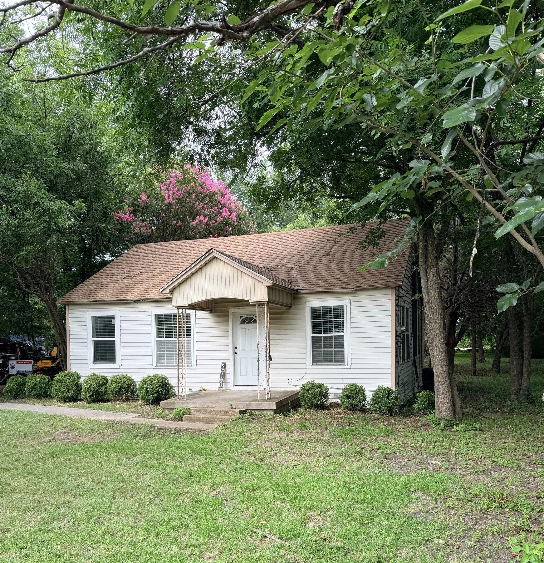 White siding exterior with a peaked roofline and covered front entry