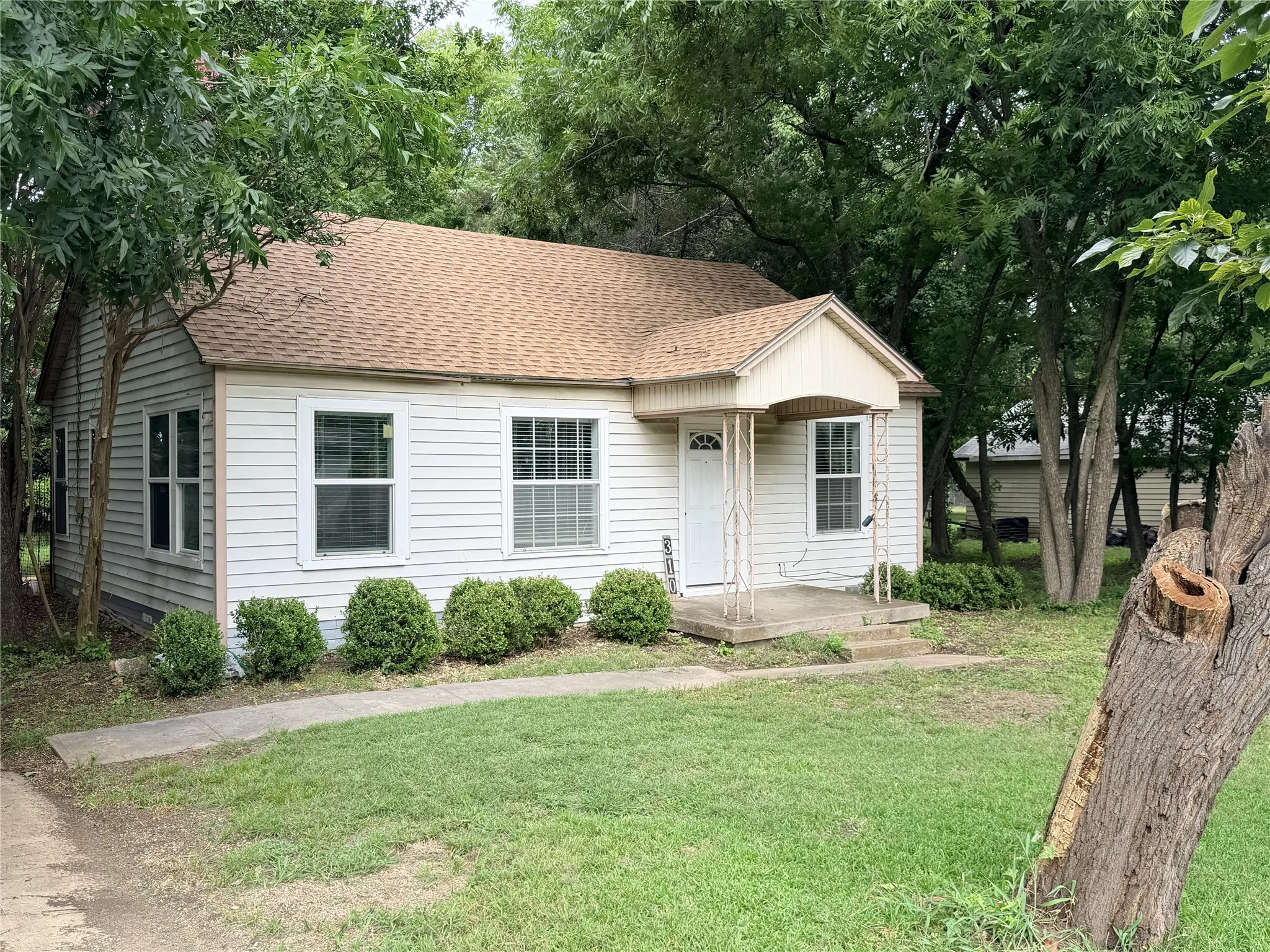 White siding exterior with a brown shingle roof