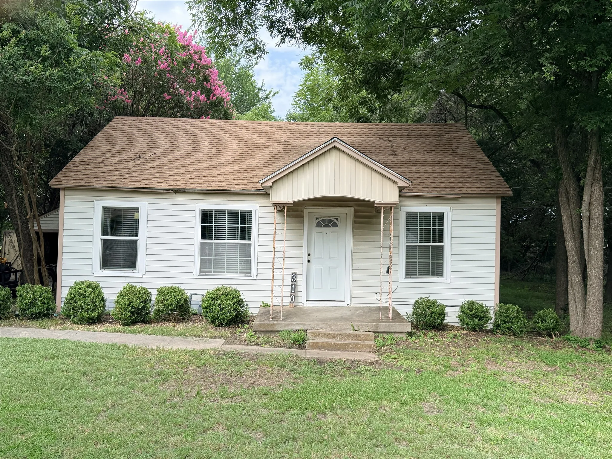 White siding exterior with a brown shingle roof