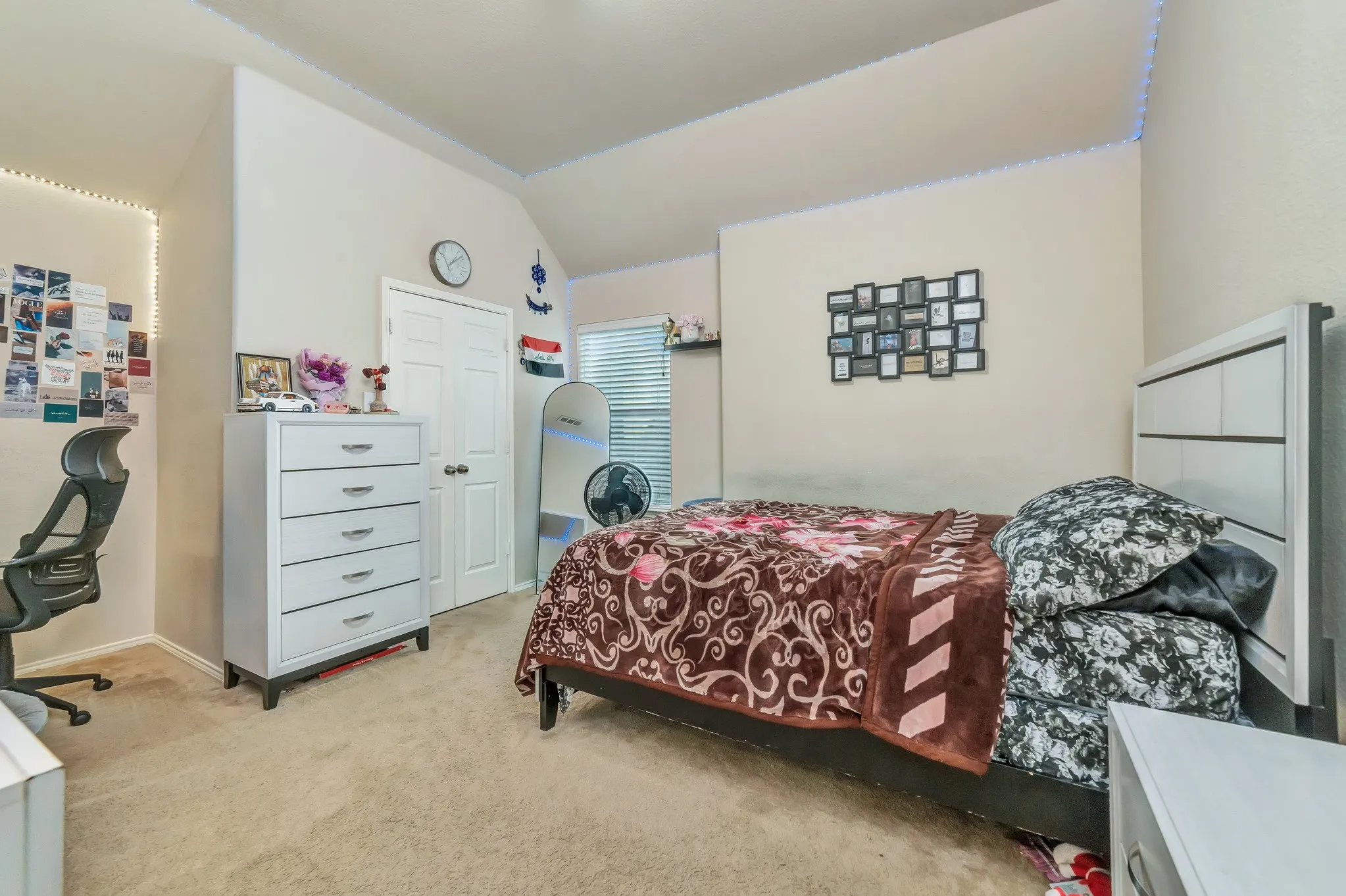Carpeted room featuring a window with horizontal blinds, a white paneled door, and a vaulted​​‌​​​​‌​​‌‌​‌‌​​​‌‌​‌​‌​‌​​​‌​​ ceiling