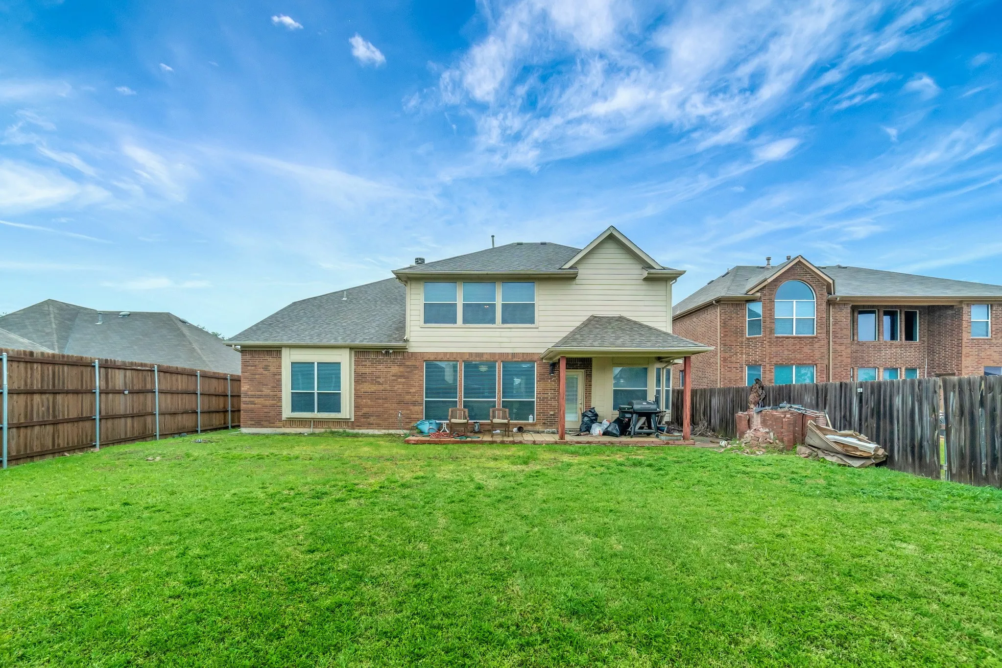Expansive green lawn with a covered patio area