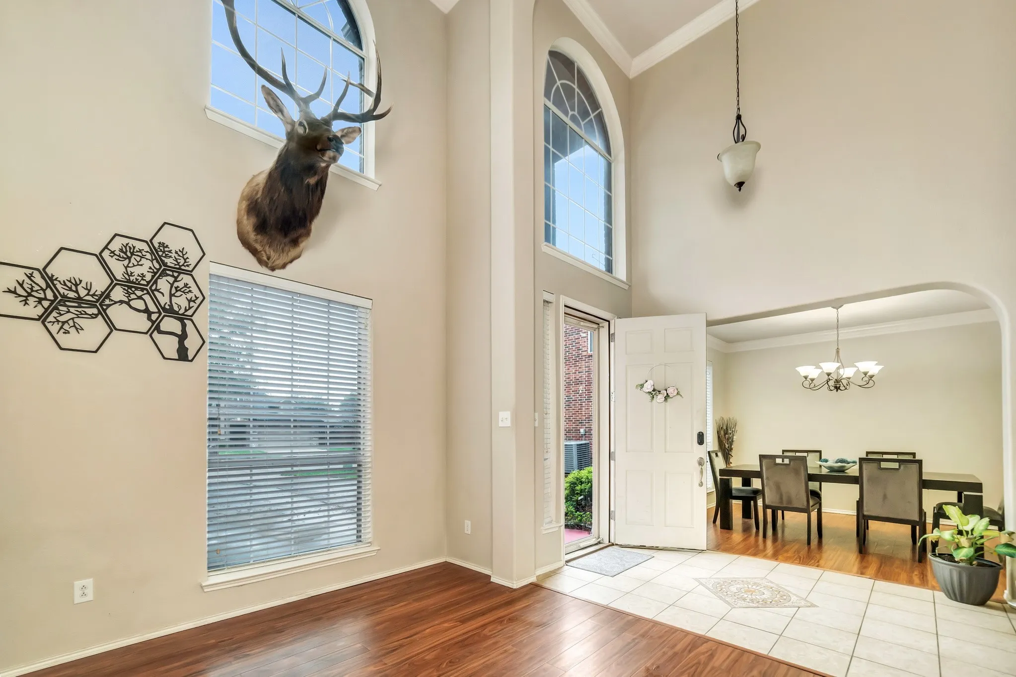 Two-story foyer with an arched window, a prominent front door, and a decorative pendant light fixture