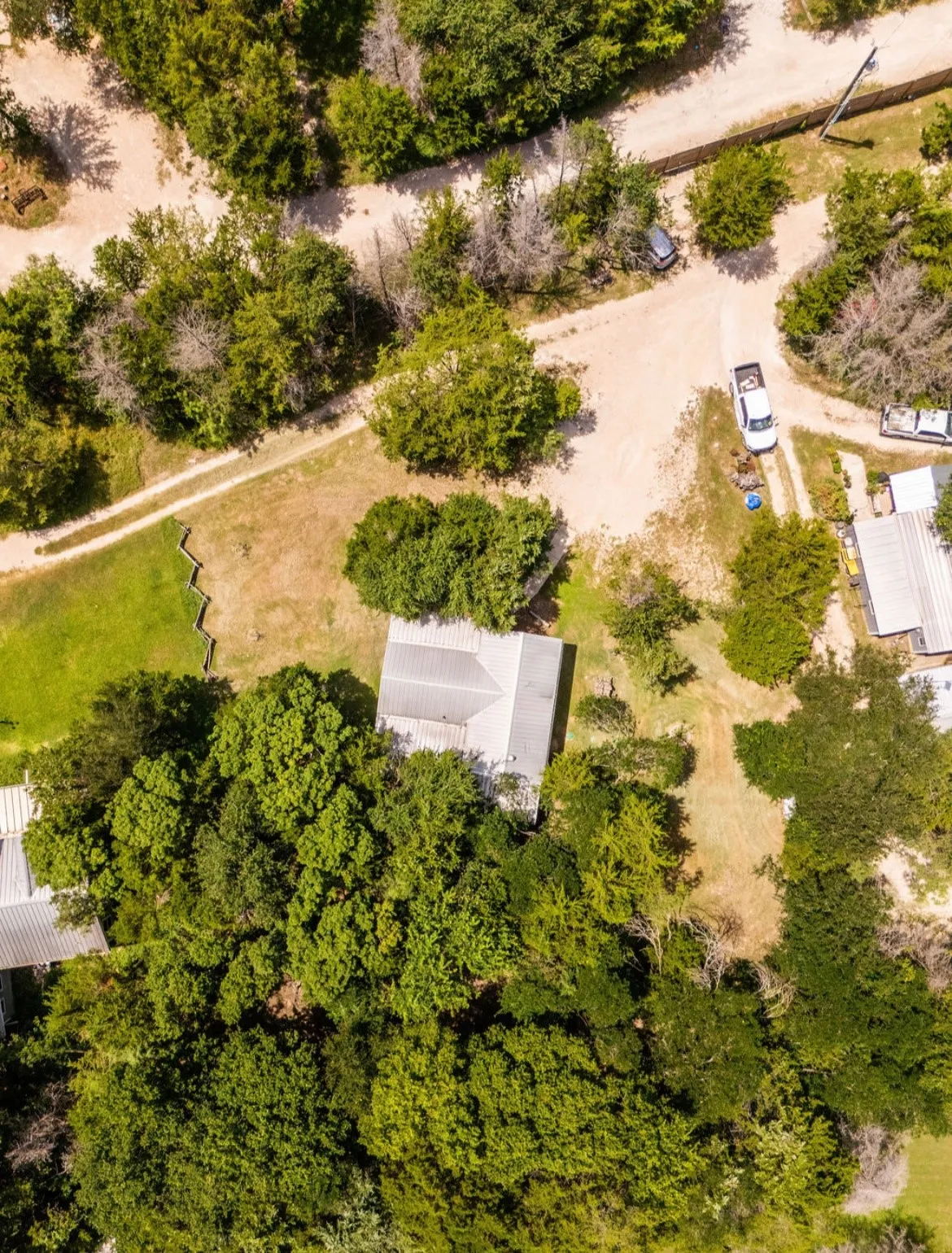 Property featuring abundant mature trees and a metal roof structure