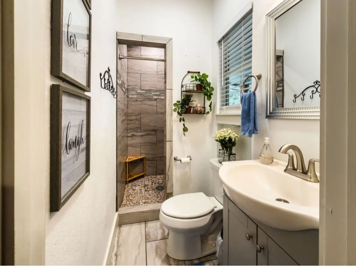 Contemporary bathroom featuring a walk-in shower with stone tile surround and pebble flooring