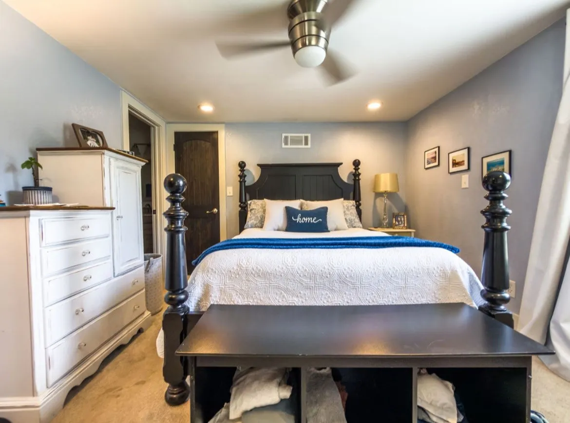 Recessed lighting illuminates this space featuring a ceiling fan with integrated lighting, a dark wood-finish door, and a built-in wall vent