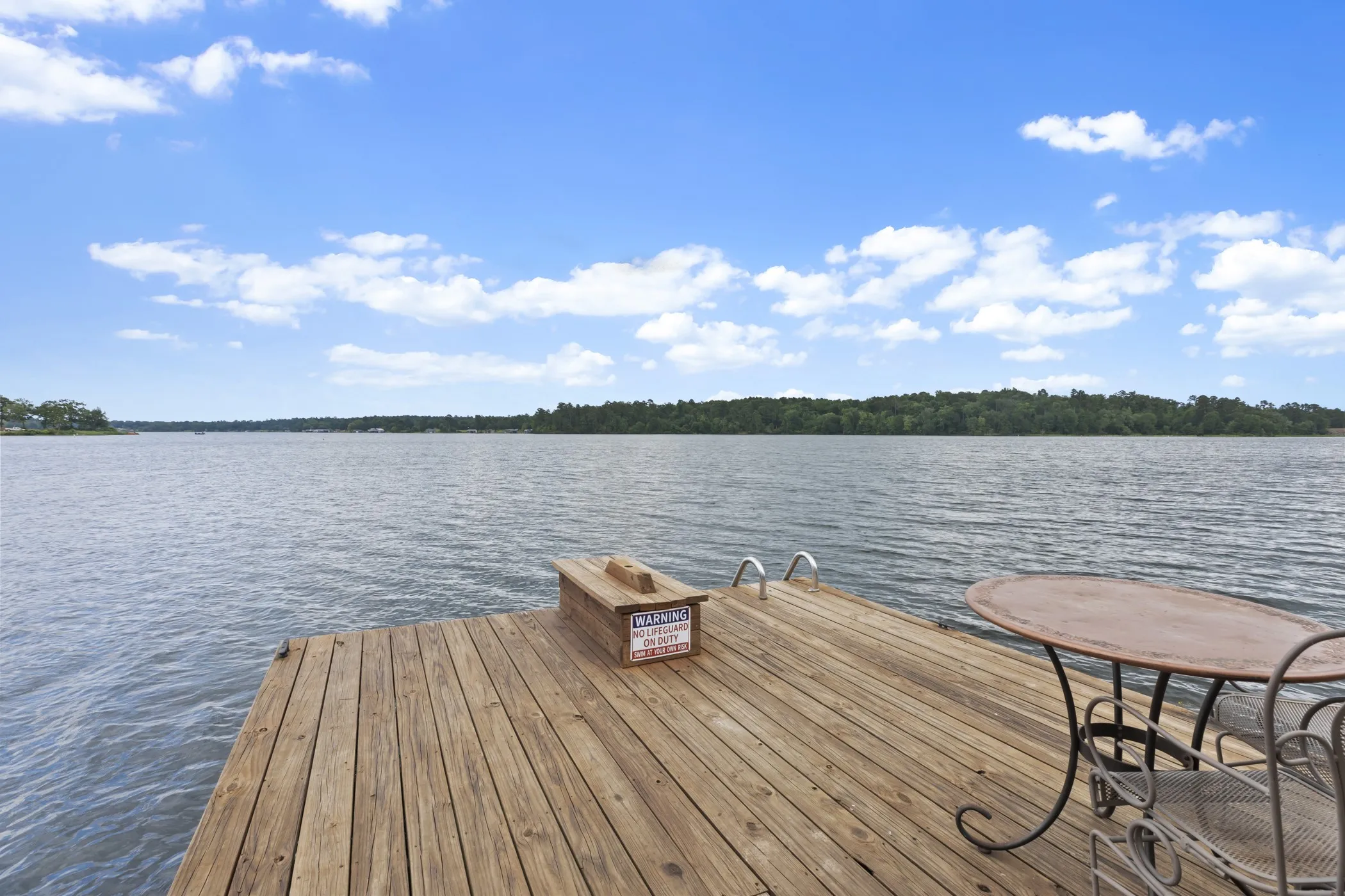 Wood dock with water access, featuring built-in steps and expansive water views