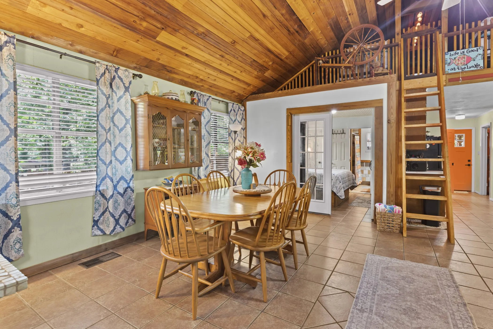 Dining area featuring a wood-plank ceiling, tile flooring, and a built-in wooden hutch