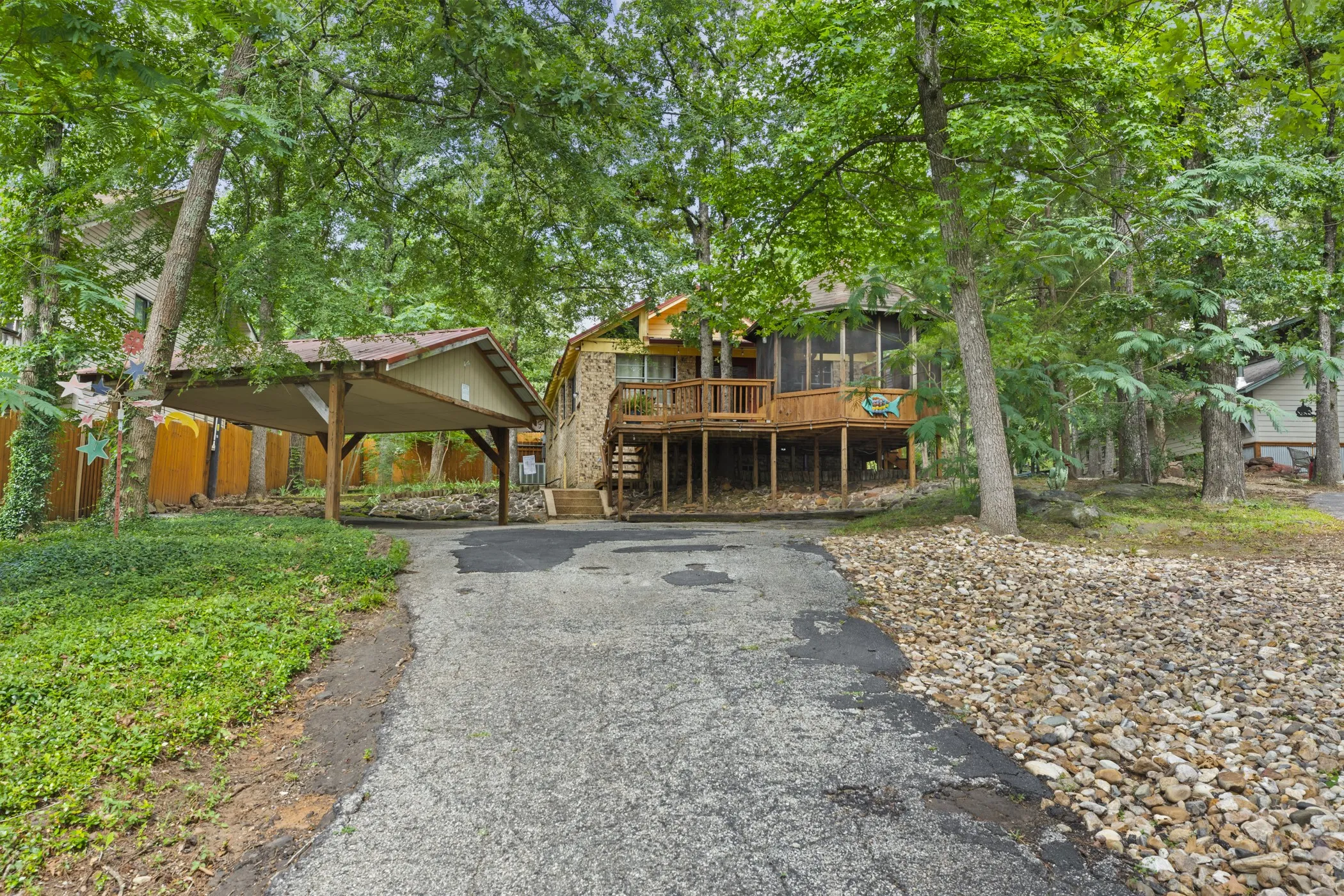 Wooded property featuring a stone and wood exterior, multiple levels, and a screened porch