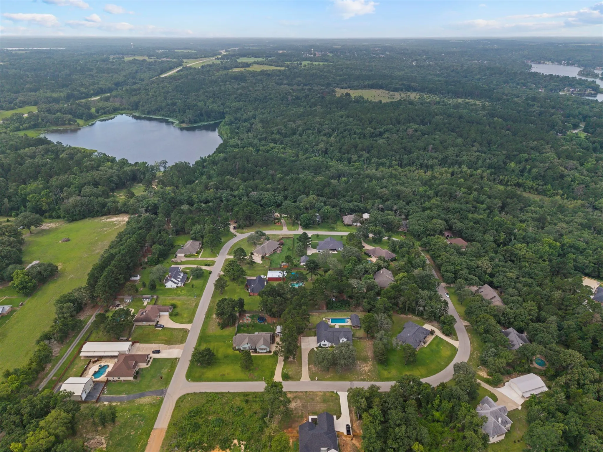 Aerial perspective showcasing a residential community surrounded by dense woodlands