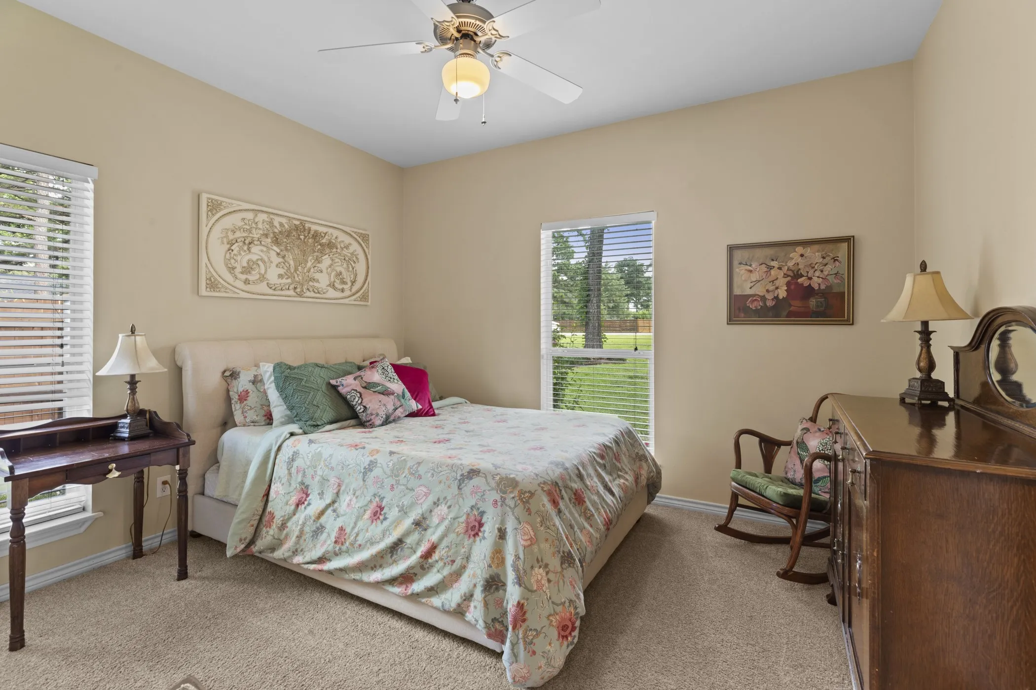 Carpeted bedroom with a vaulted ceiling and a ceiling fan