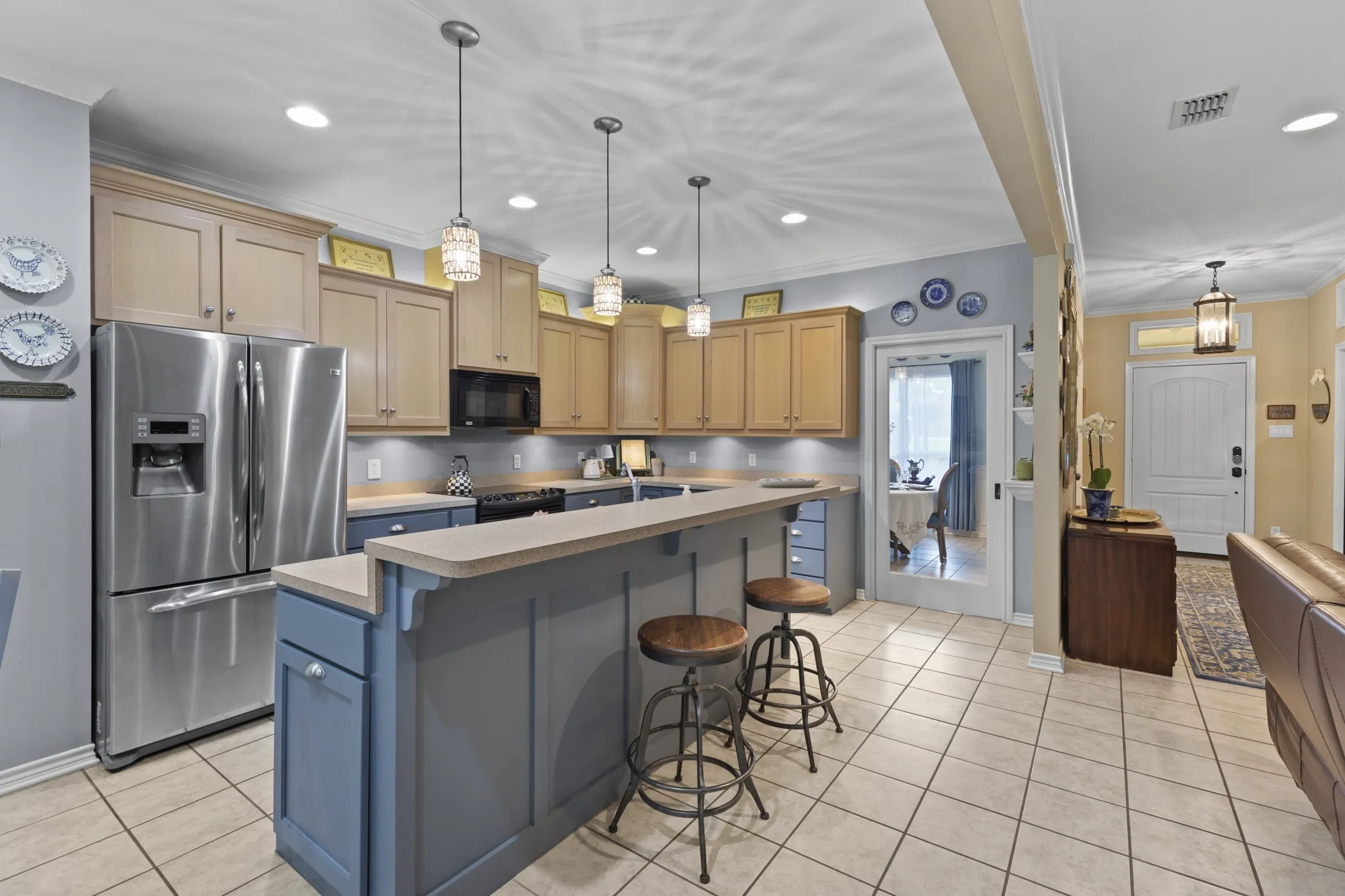 Kitchen featuring a breakfast bar with seating, stainless steel appliances, recessed lighting, pendant light fixtures, and tile flooring