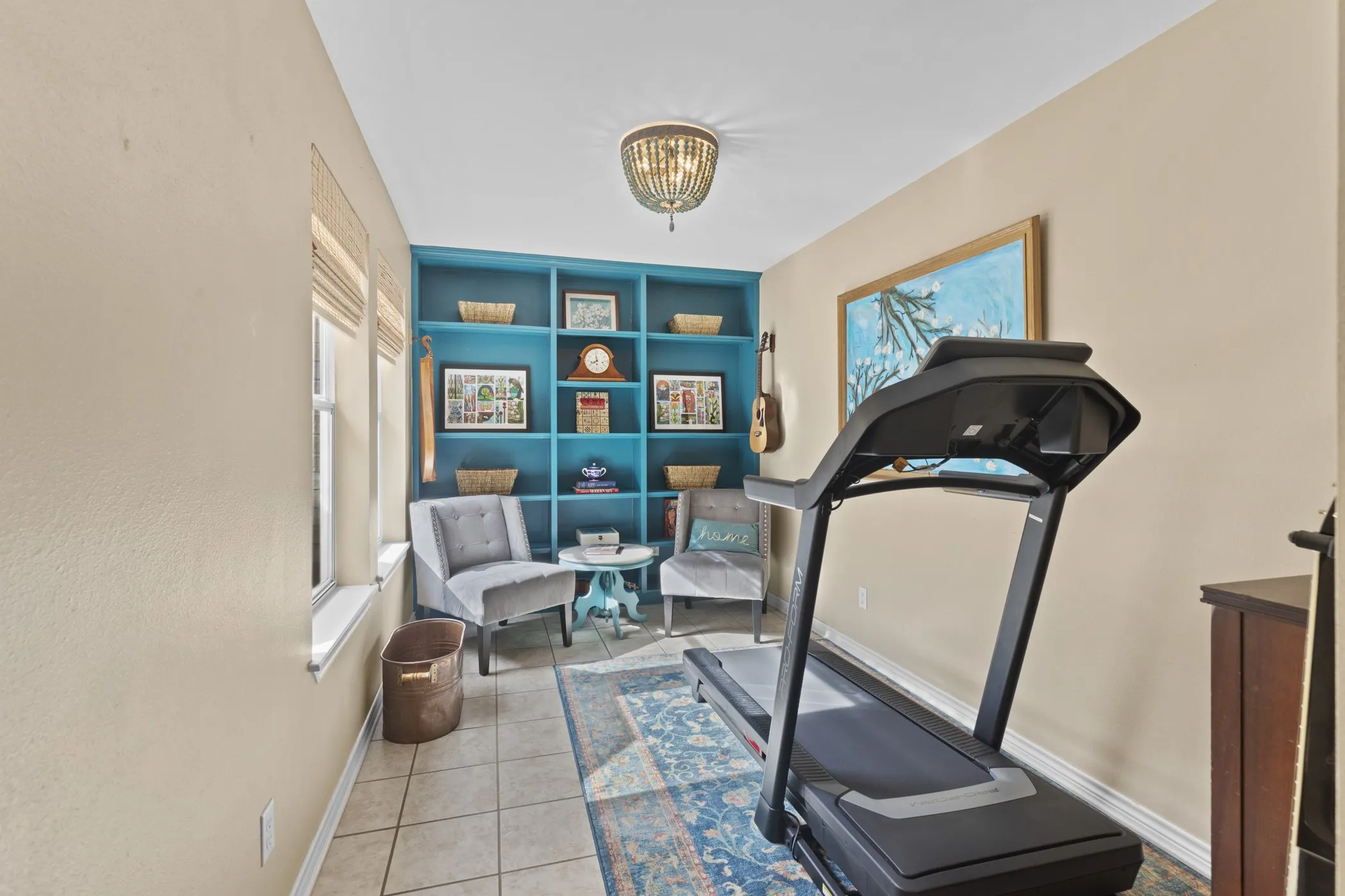 Dedicated room featuring built-in shelving, tile flooring, and multiple windows
