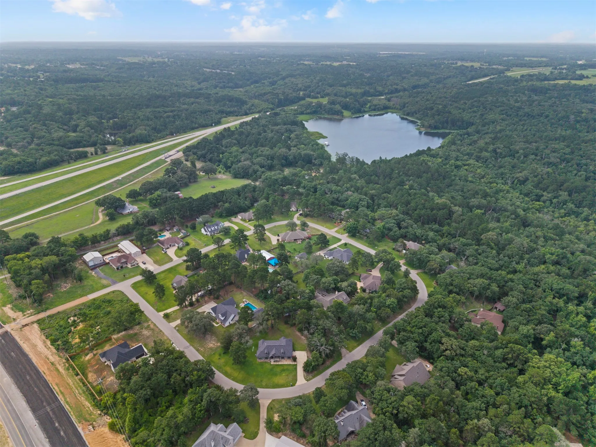 Aerial panorama showcasing a residential area surrounded by dense woodlands