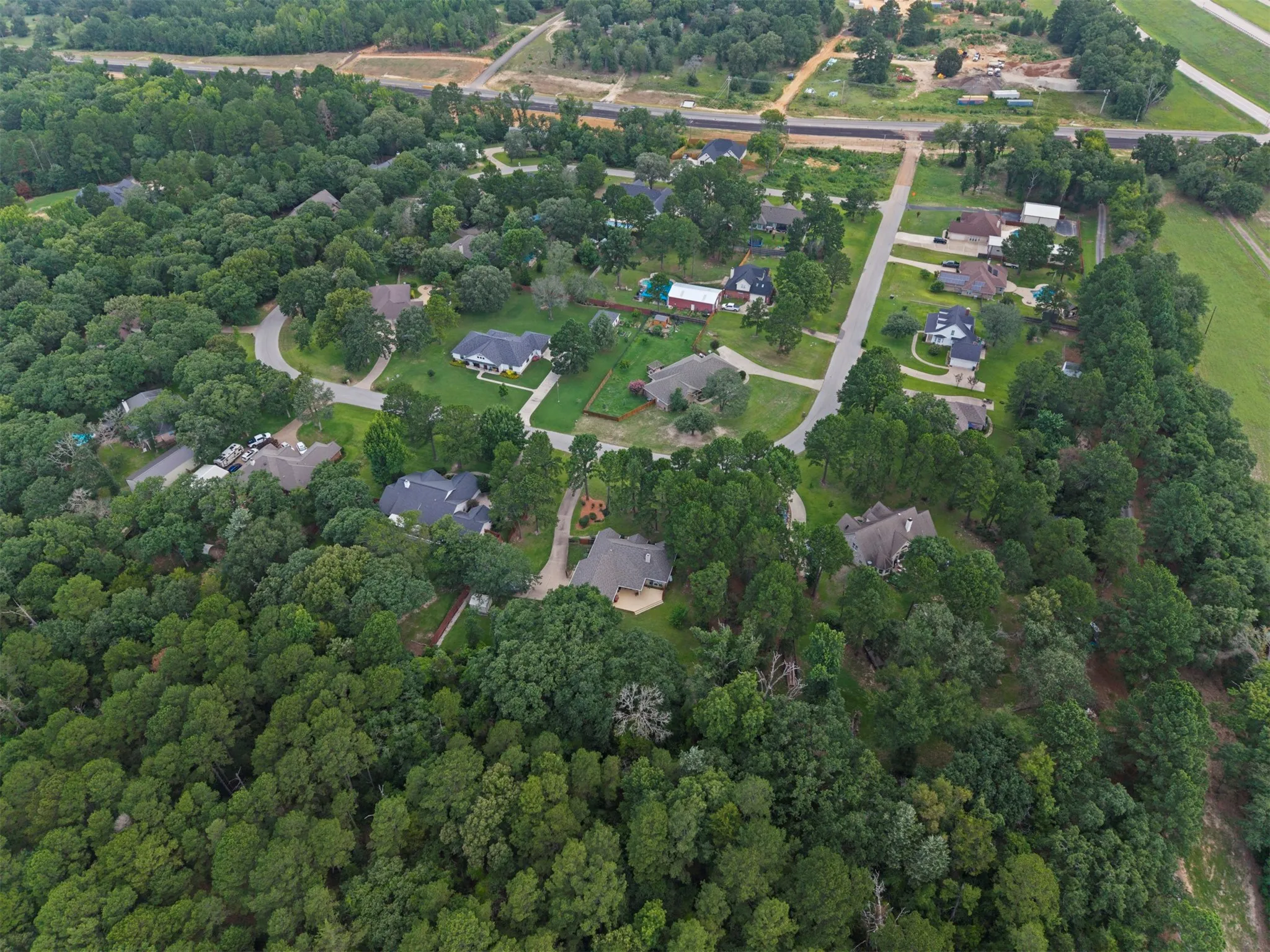 Aerial perspective showcasing a residential community within a heavily wooded area