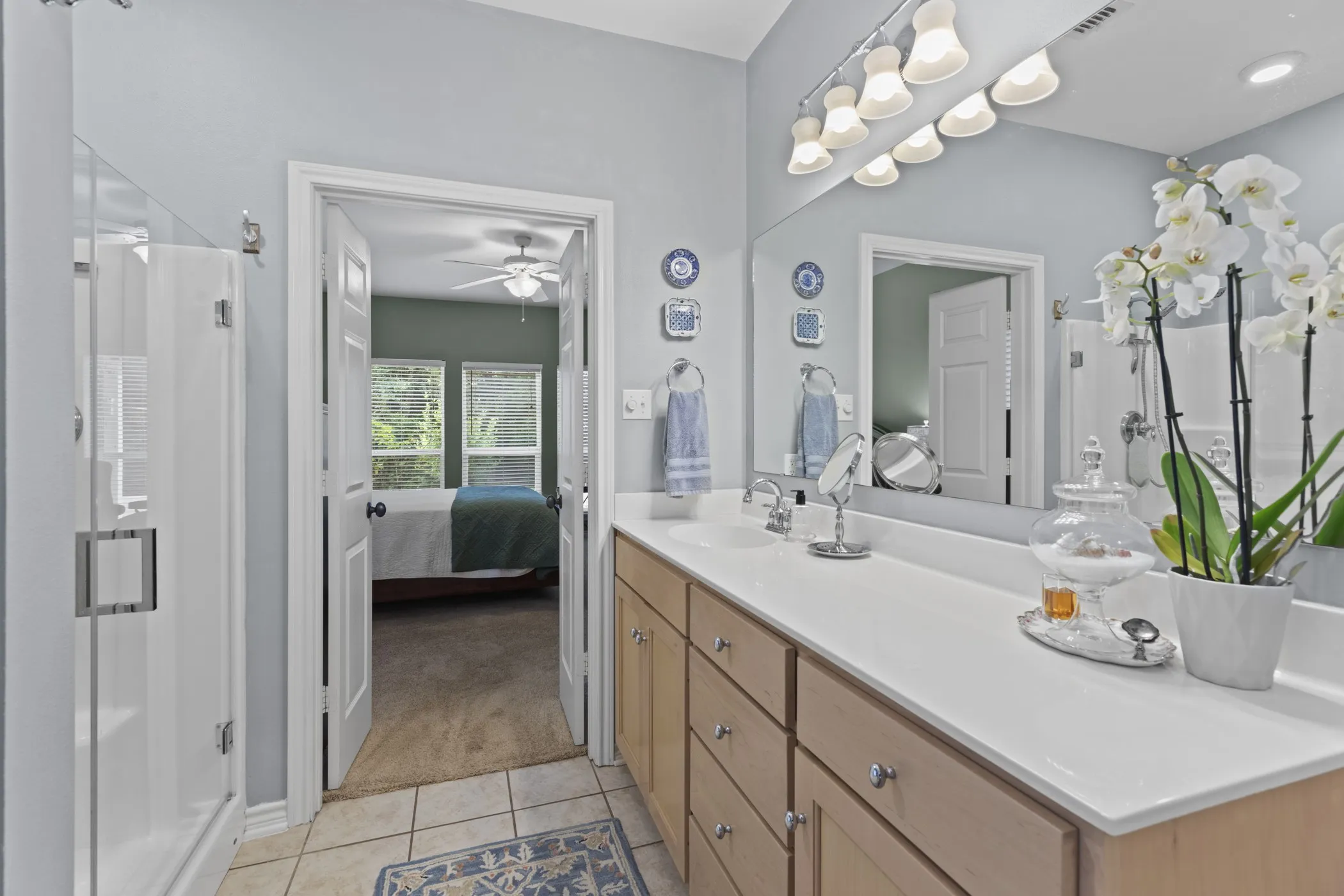 Double vanity with light wood-finish cabinetry and white countertop