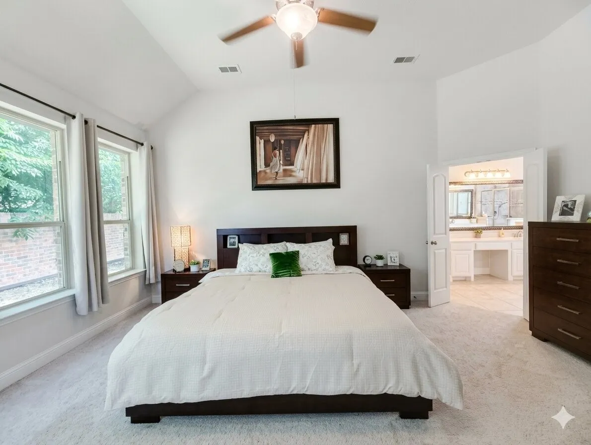 Vaulted ceiling bedroom with light-colored carpeting