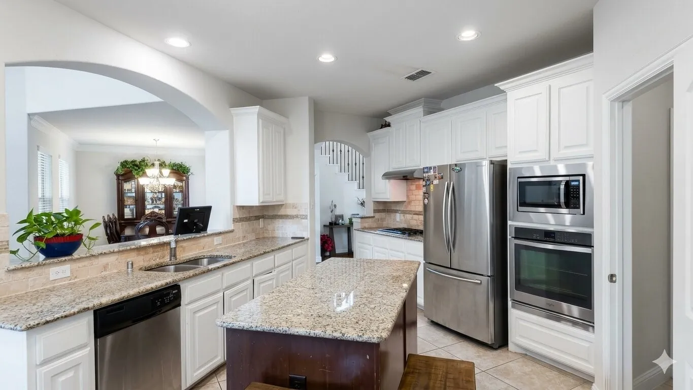 Kitchen featuring light-toned countertops, white cabinetry, a built-in oven and microwave, stainless steel appliances, and an island