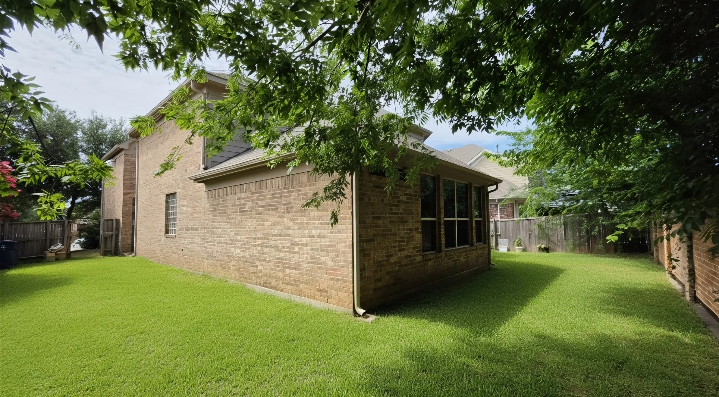 Expansive green lawn with a brick exterior and multiple windows