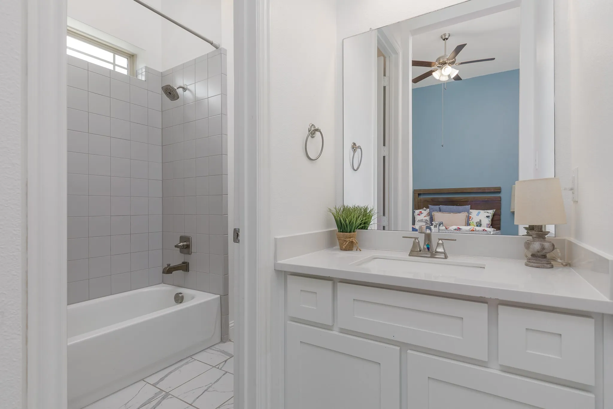 Bathroom featuring a white vanity with a light-toned countertop, a rectangular sink with a chrome faucet, and white cabinetry