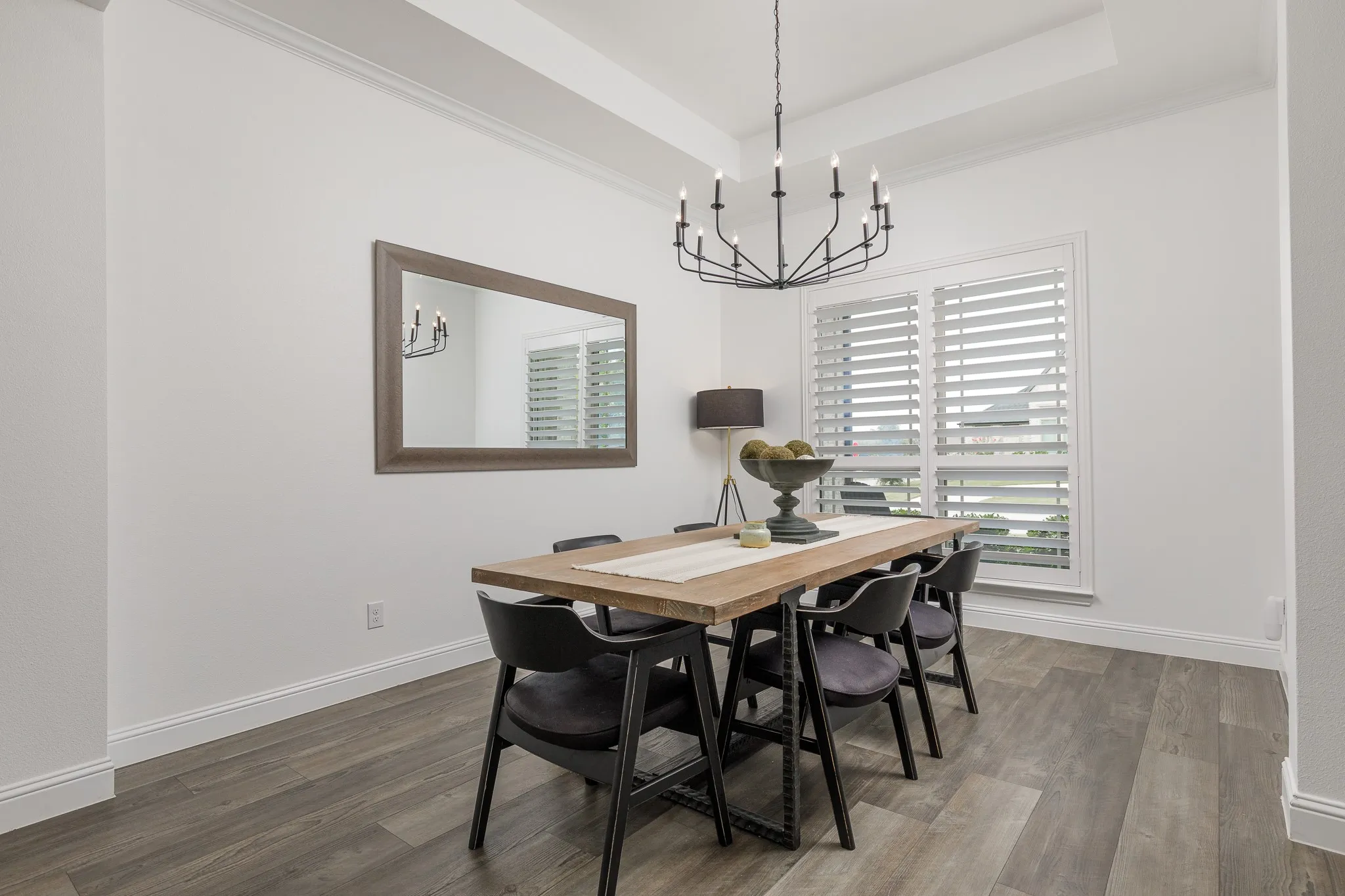 Spacious room featuring wood-finish flooring, a tray ceiling, and crown molding