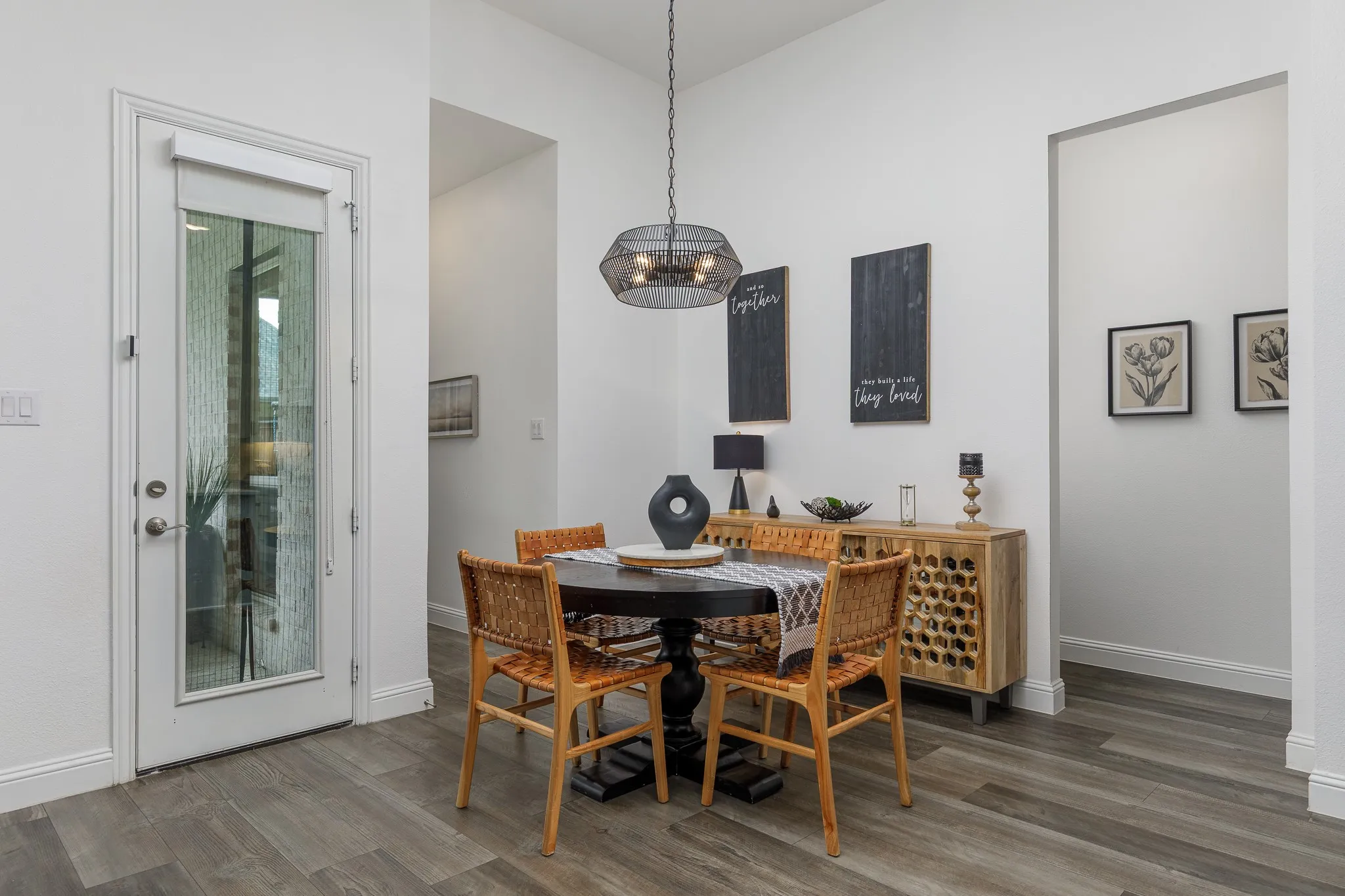Open-concept dining area featuring wood-finish flooring and a contemporary pendant light fixture