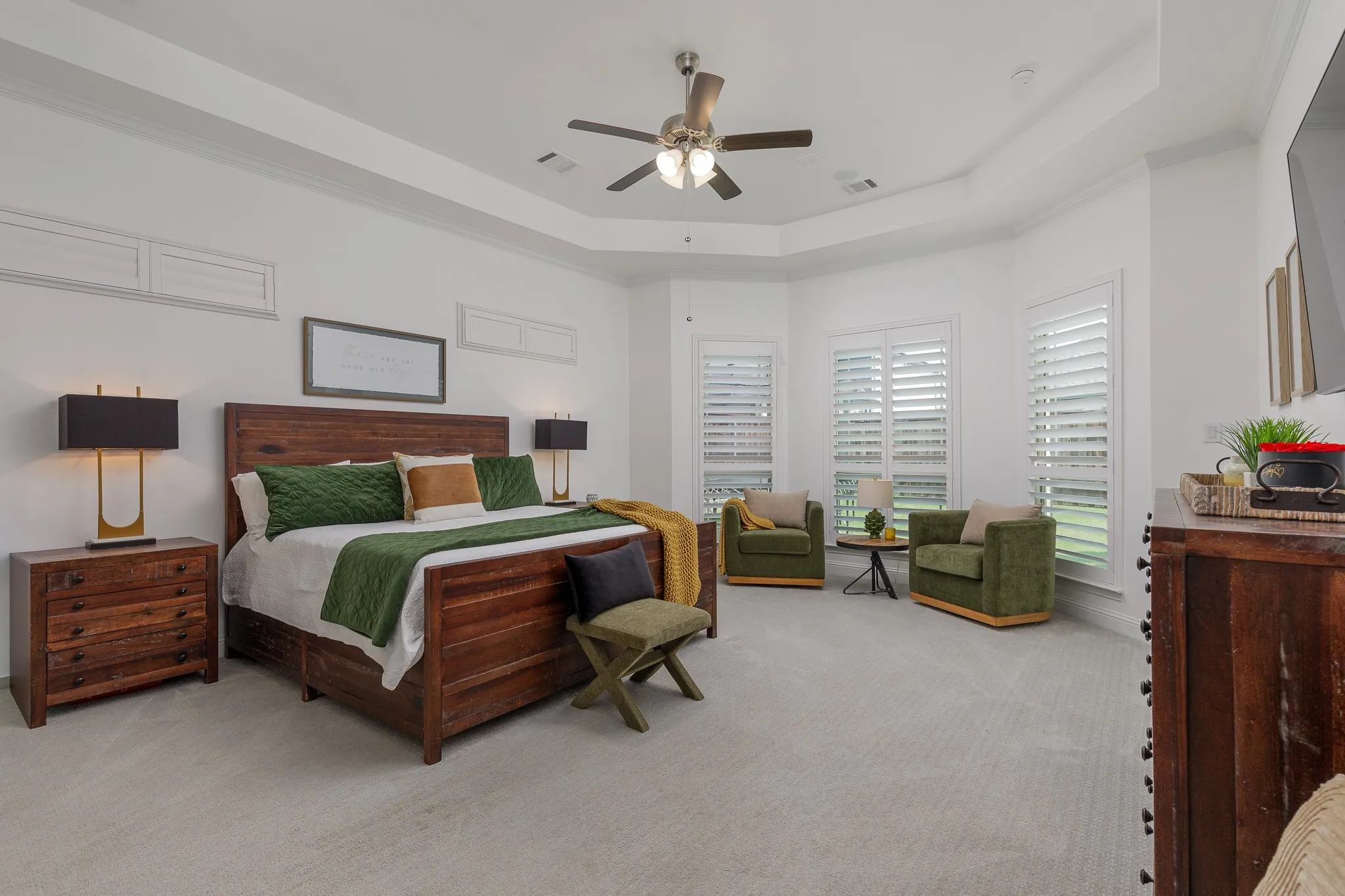 Spacious bedroom featuring a tray ceiling, recessed lighting, and a ceiling fan