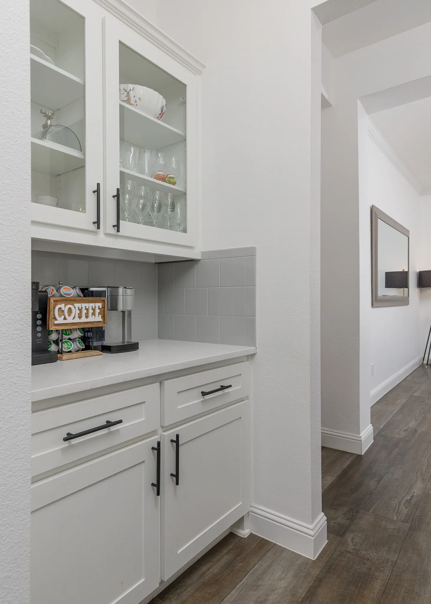 Built-in cabinetry with glass-front upper cabinets, solid lower cabinets, and black hardware