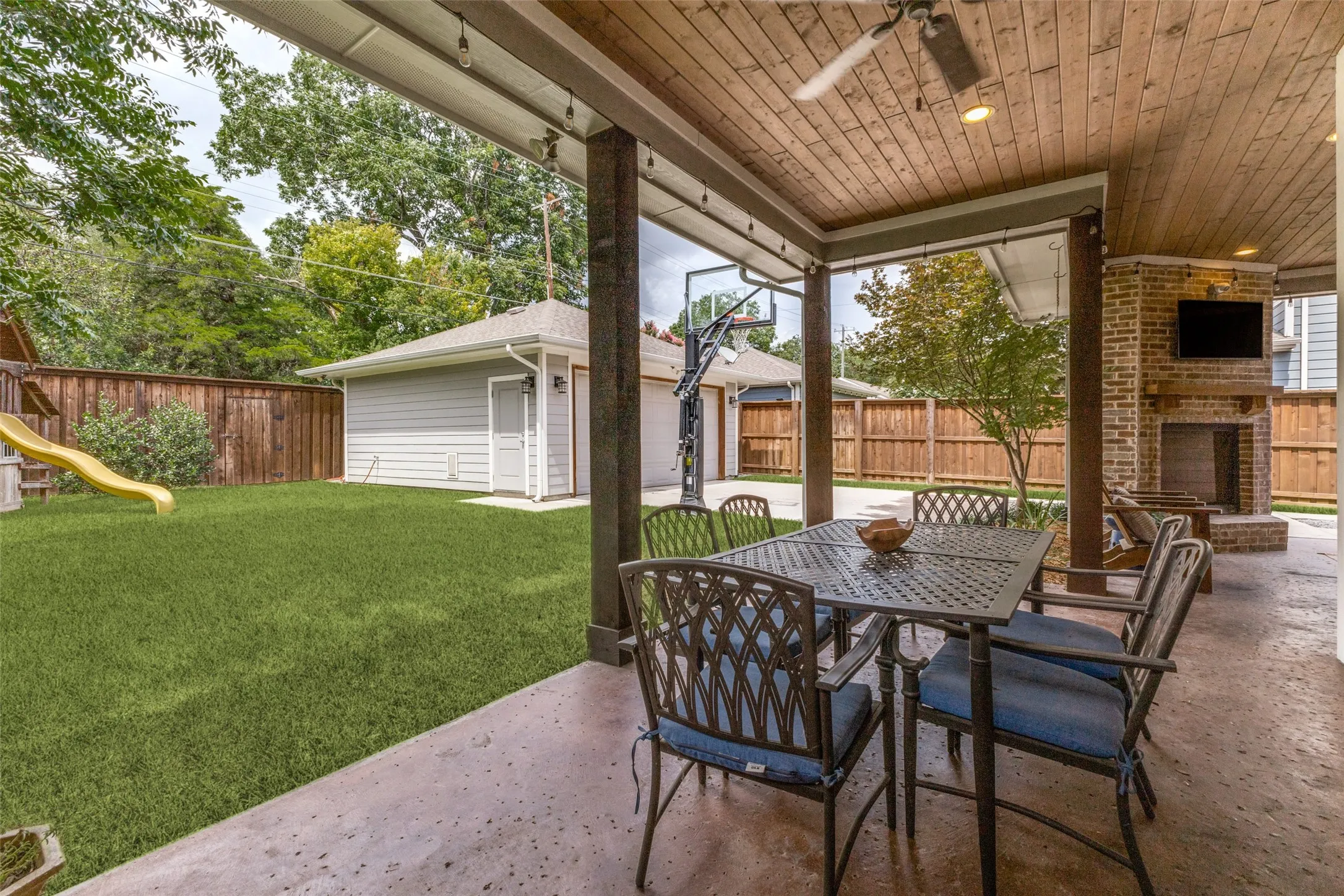 outdoor dining with stained concrete flooring and view to fireplace and second seating area