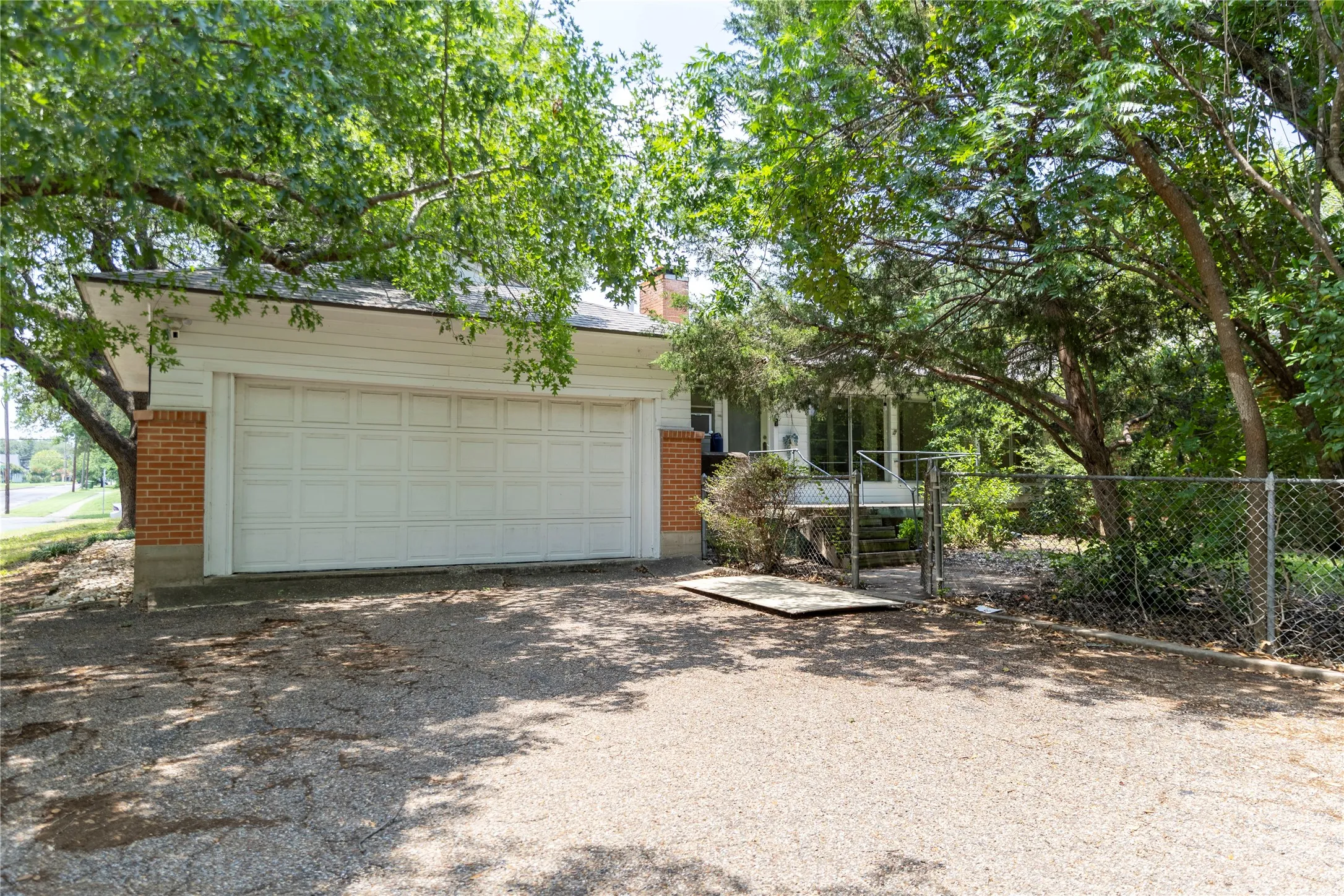 Two-car garage with white panel door and brick accents