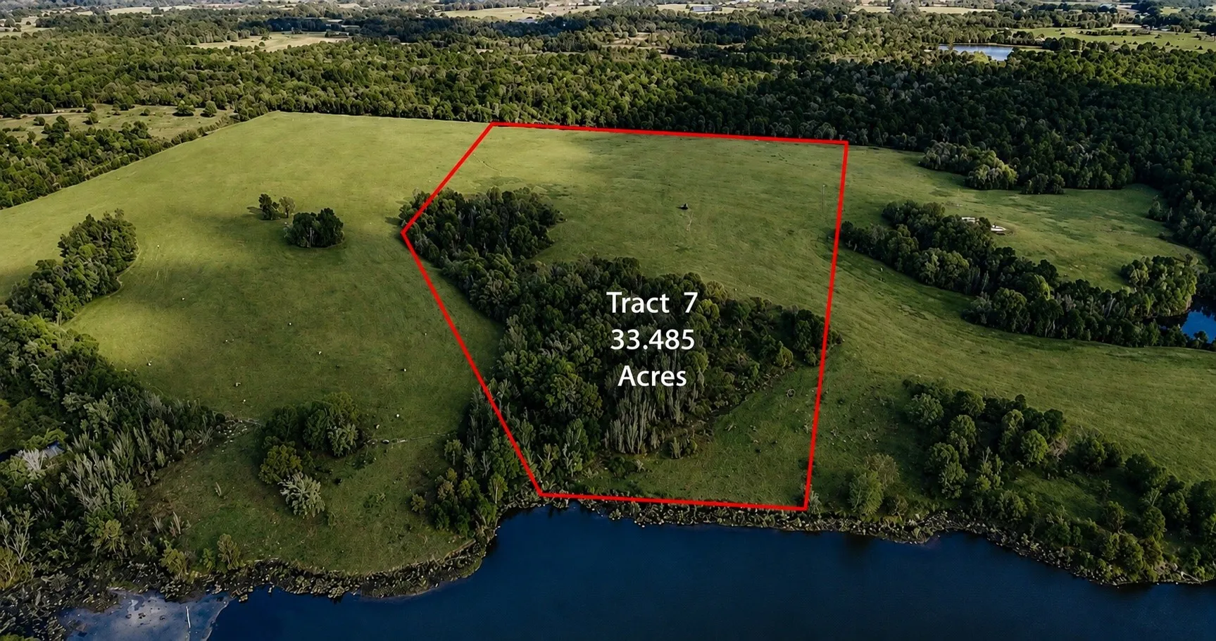 Expansive 33.485-acre parcel, Tract 7, featuring a large cleared field area, wooded sections, and direct water frontage