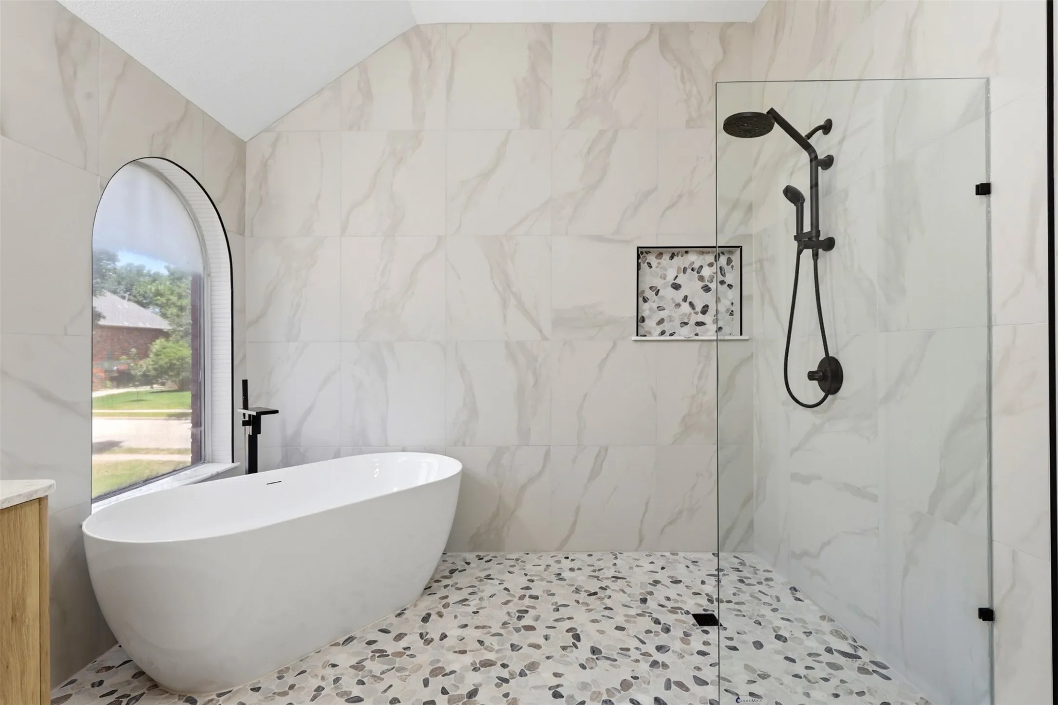 Contemporary bathroom featuring a freestanding soaking tub and an arched window