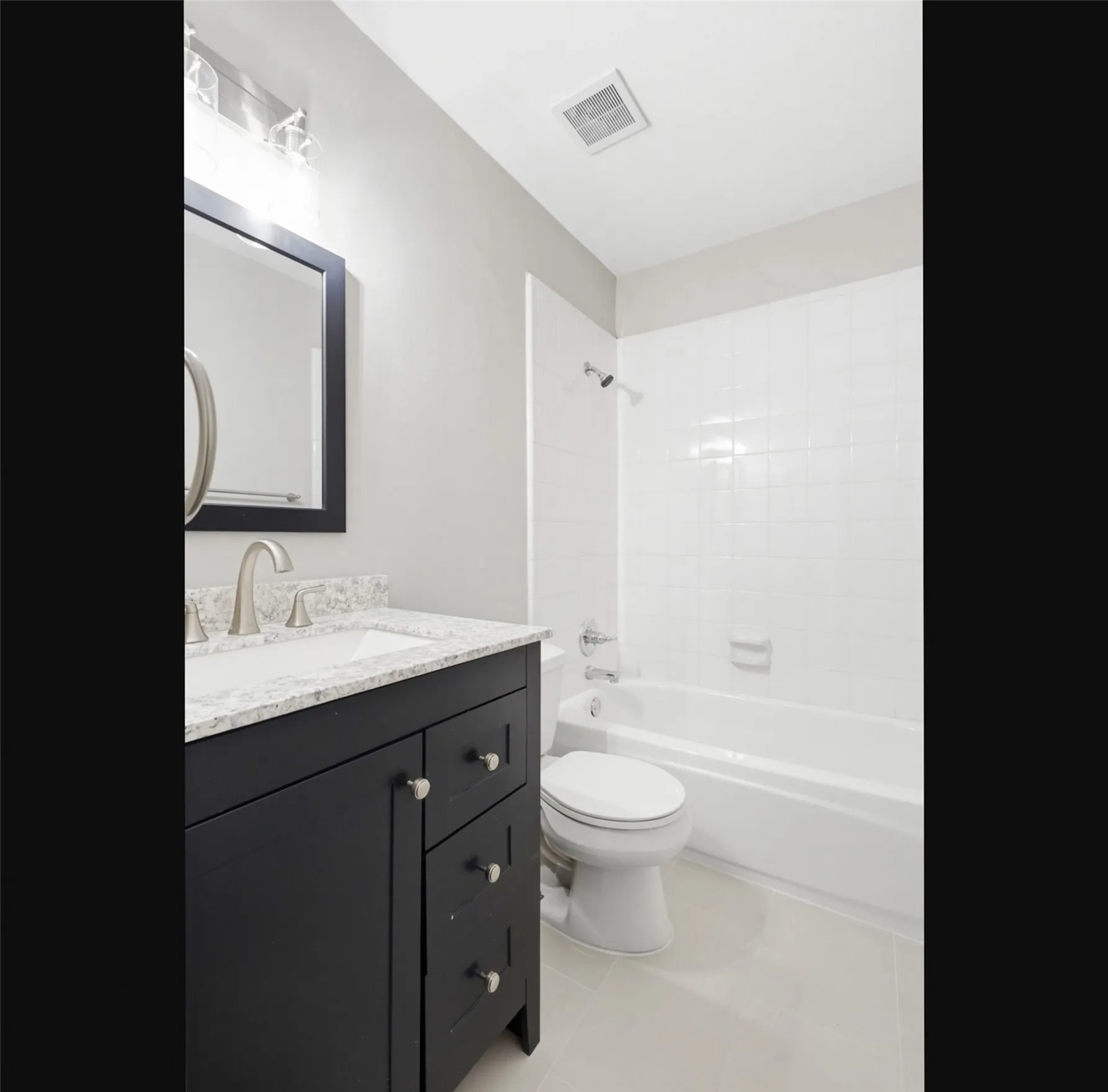 Bathroom featuring a dark wood vanity with a light-toned countertop and an undermount sink