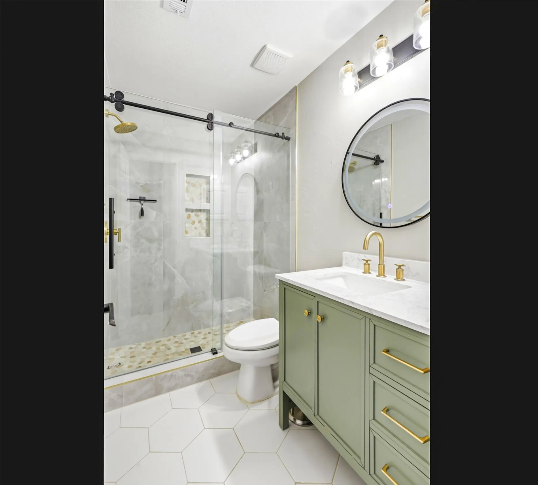 Contemporary bathroom featuring a sage green vanity with gold-tone hardware, a white countertop, and a round mirror