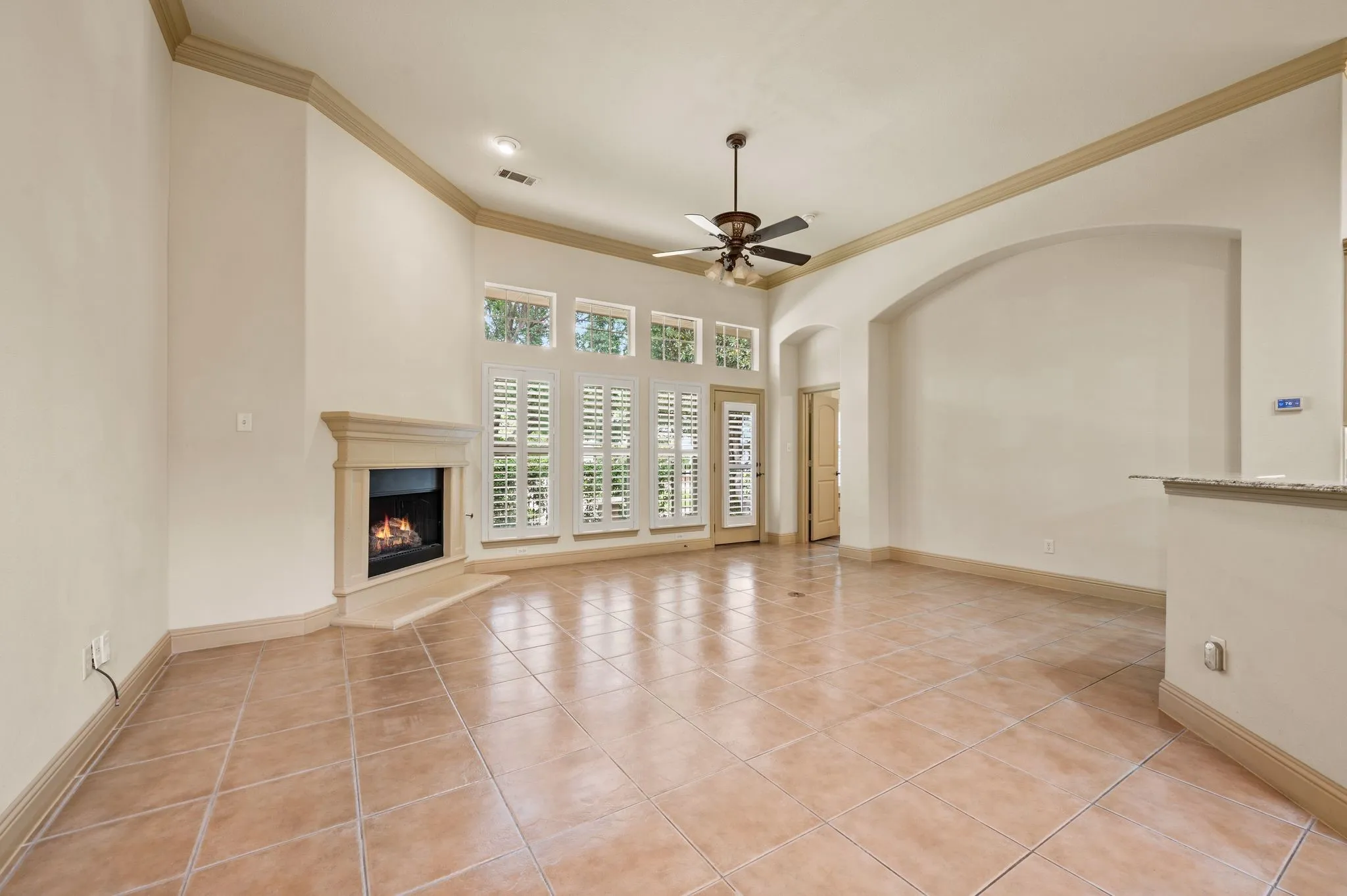 Main Living Area Featuring a Gas Fireplace, Vaulted Ceilings, and Lovely View of Patio