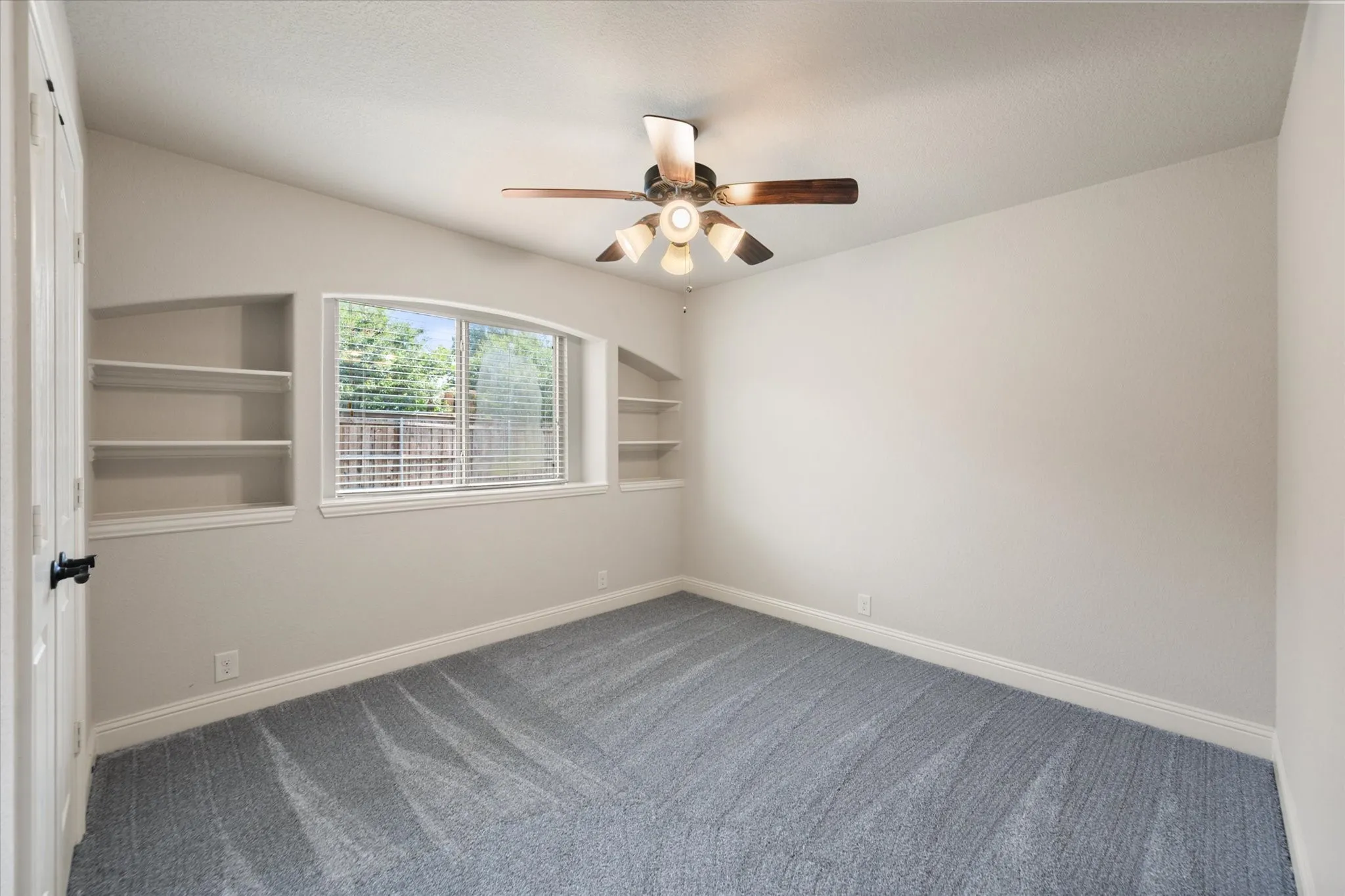Room featuring vaulted ceilings, a ceiling fan with light fixture, light gray walls, and gray patterned carpeting