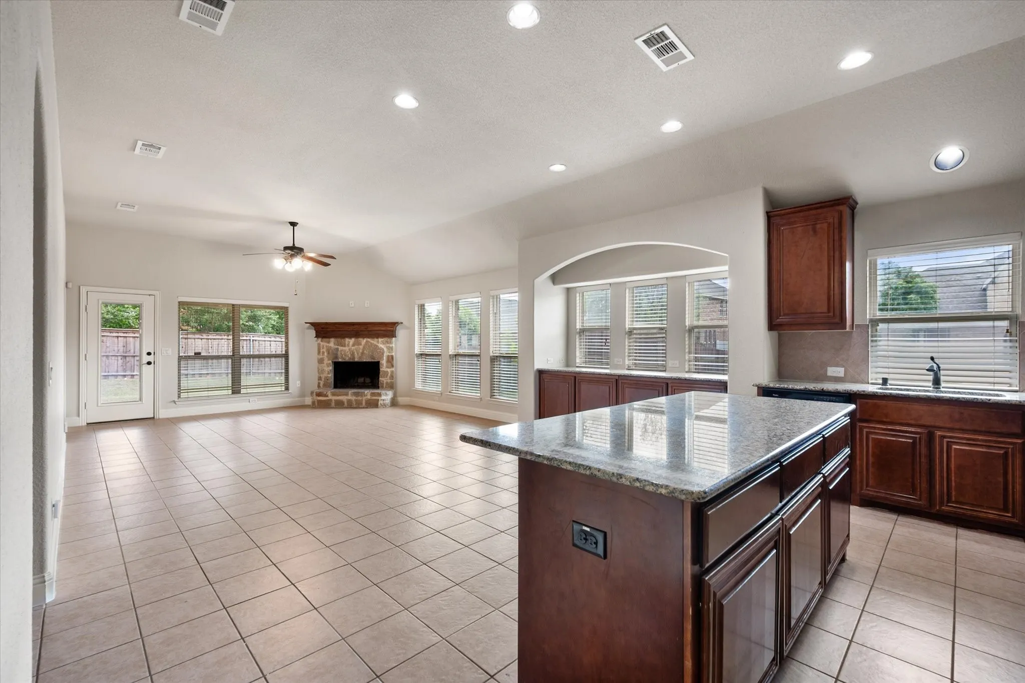Open-concept living area with a fireplace & recessed lighting