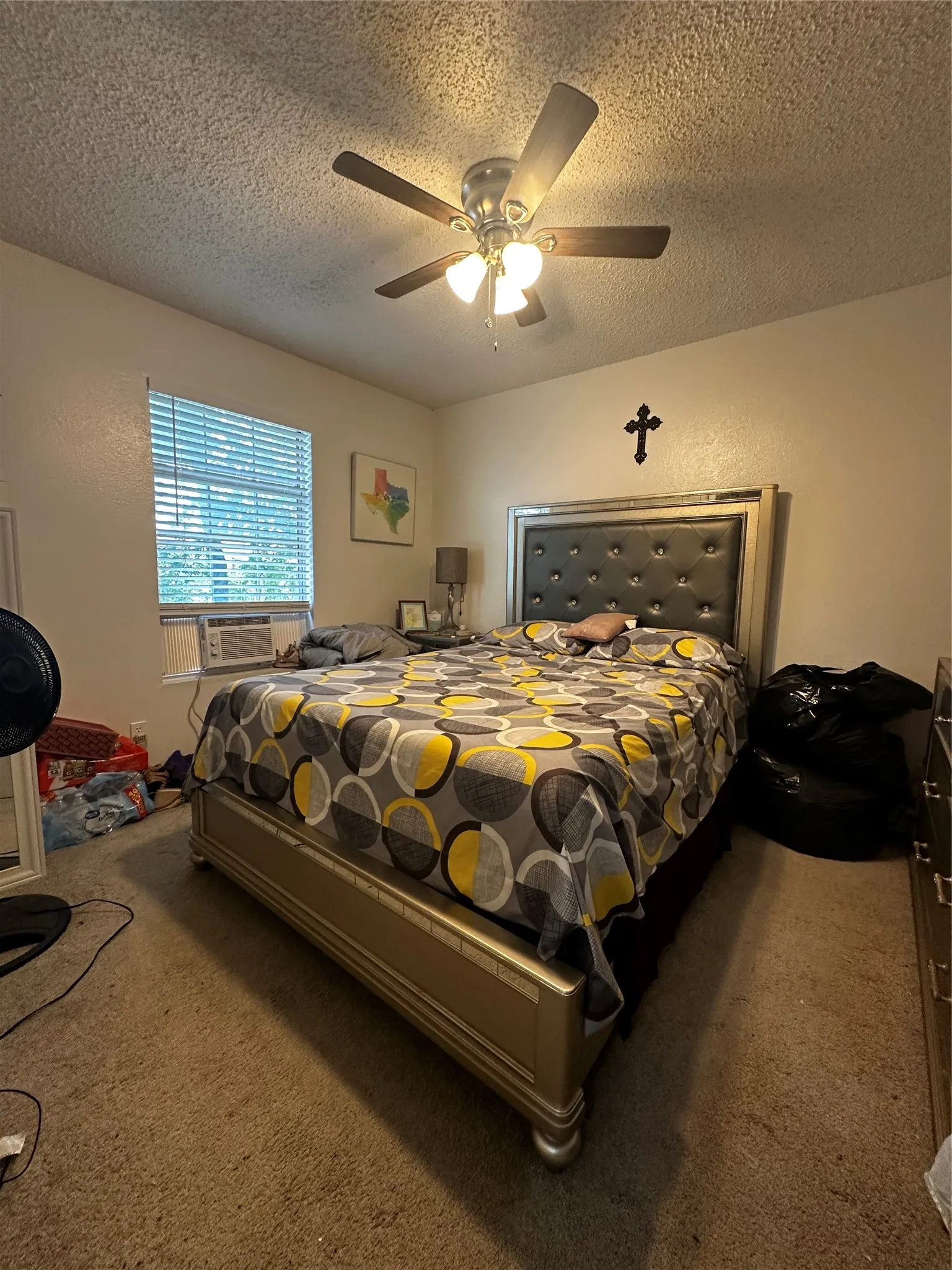 Carpeted interior space featuring a window with horizontal blinds, a ceiling fan with integrated lighting, and painted walls